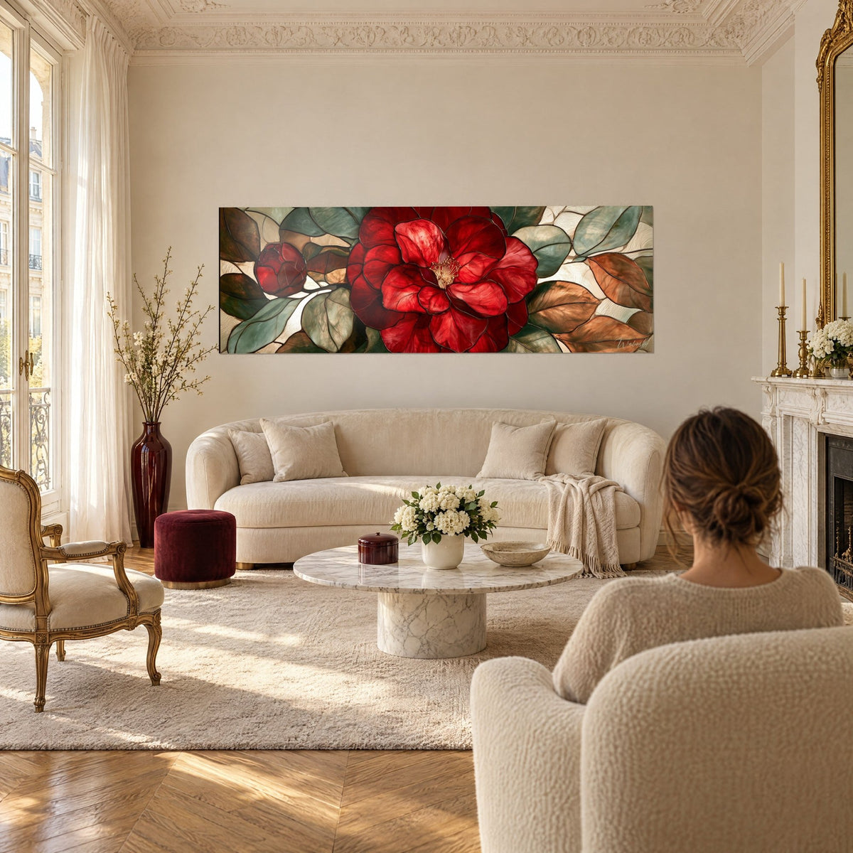 Wall art with a scarlet camellia, petals like stained glass, sage green and copper leaves, above a sofa in a bright living room