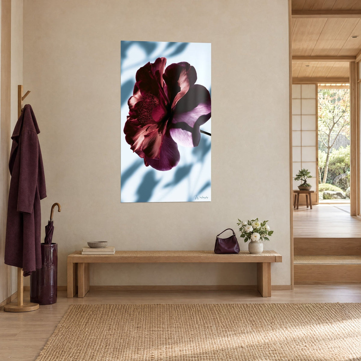 Cuadro flor de pétalos burdeos y malva veteados, estambres oscuros, fondo azul glaciar, vista de tres cuartos en un recibidor japandi