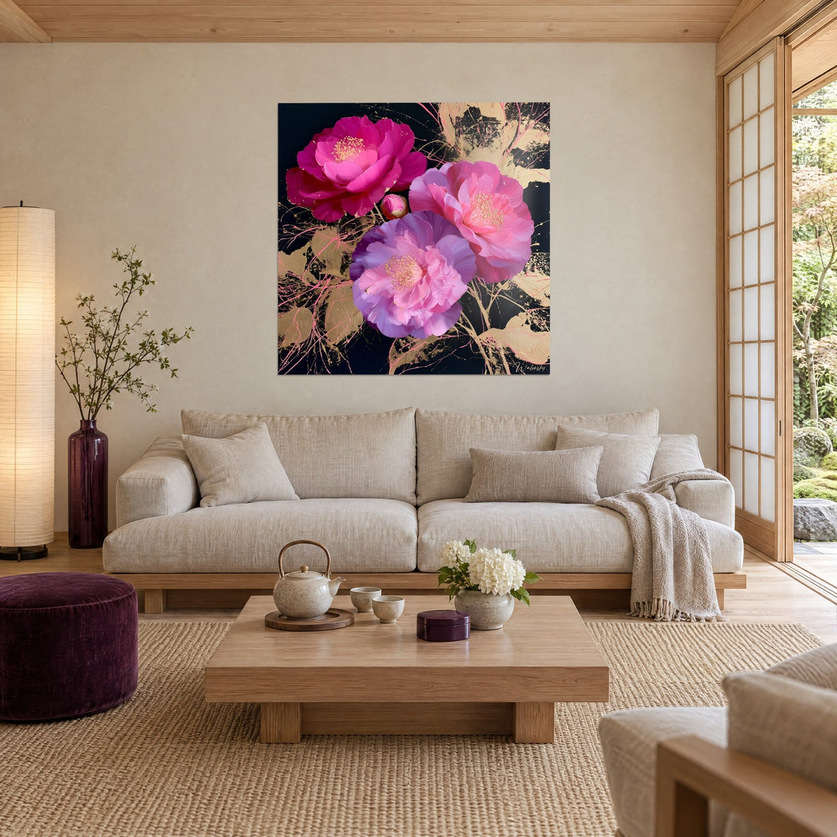 Tableau camélias fuchsia et mauves aux étamines dorées sur fond noir, éclaboussures d'or, au-dessus d'un canapé dans un salon lumineux