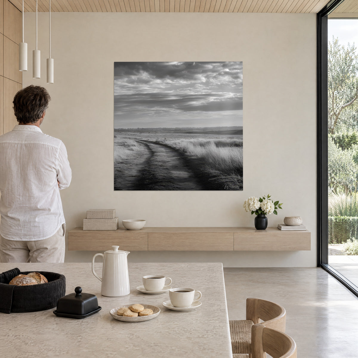 Wall art Marsh landscape under a stormy sky, charcoal black and silver grey, winding path toward the horizon, facing a man in a linen shirt