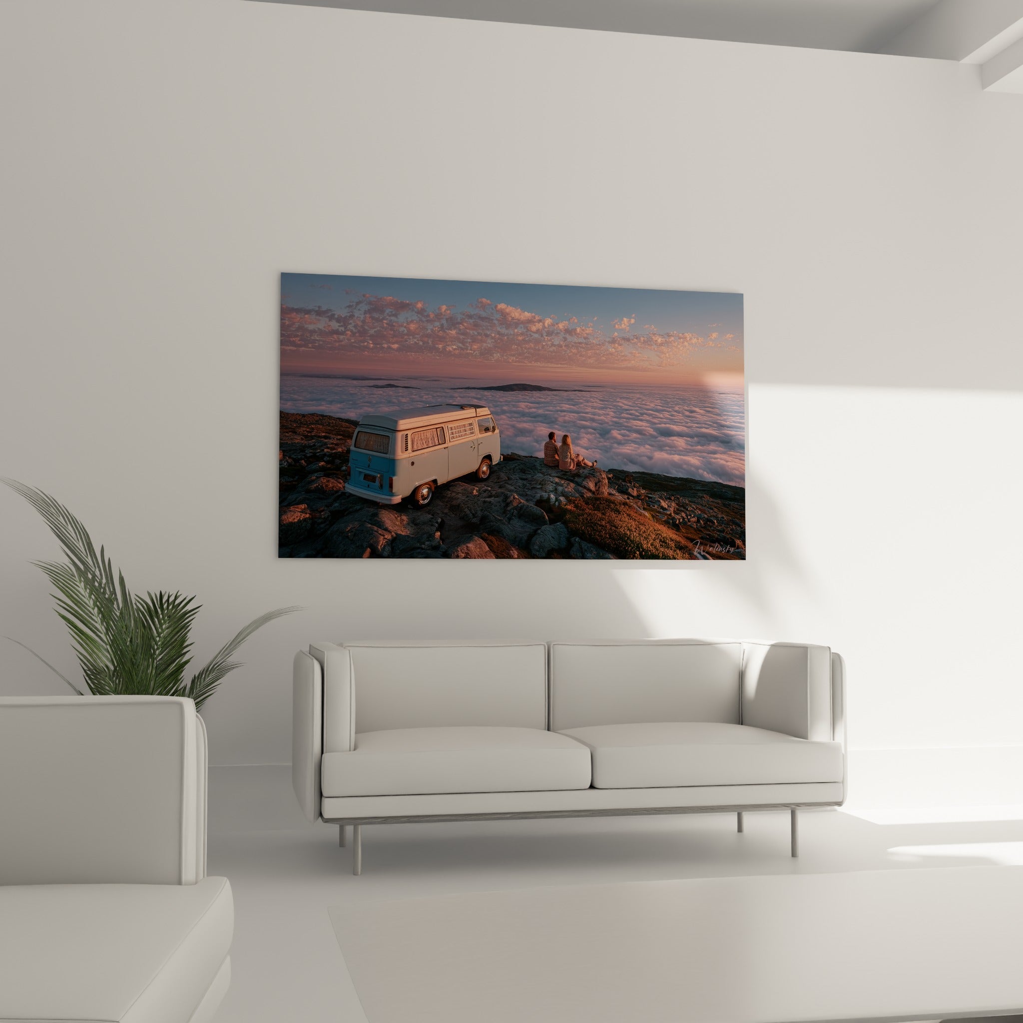 Couple contemplant l'horizon depuis un promontoire rocheux, van bleu ciel, au-dessus d'un canapé dans un salon lumineux