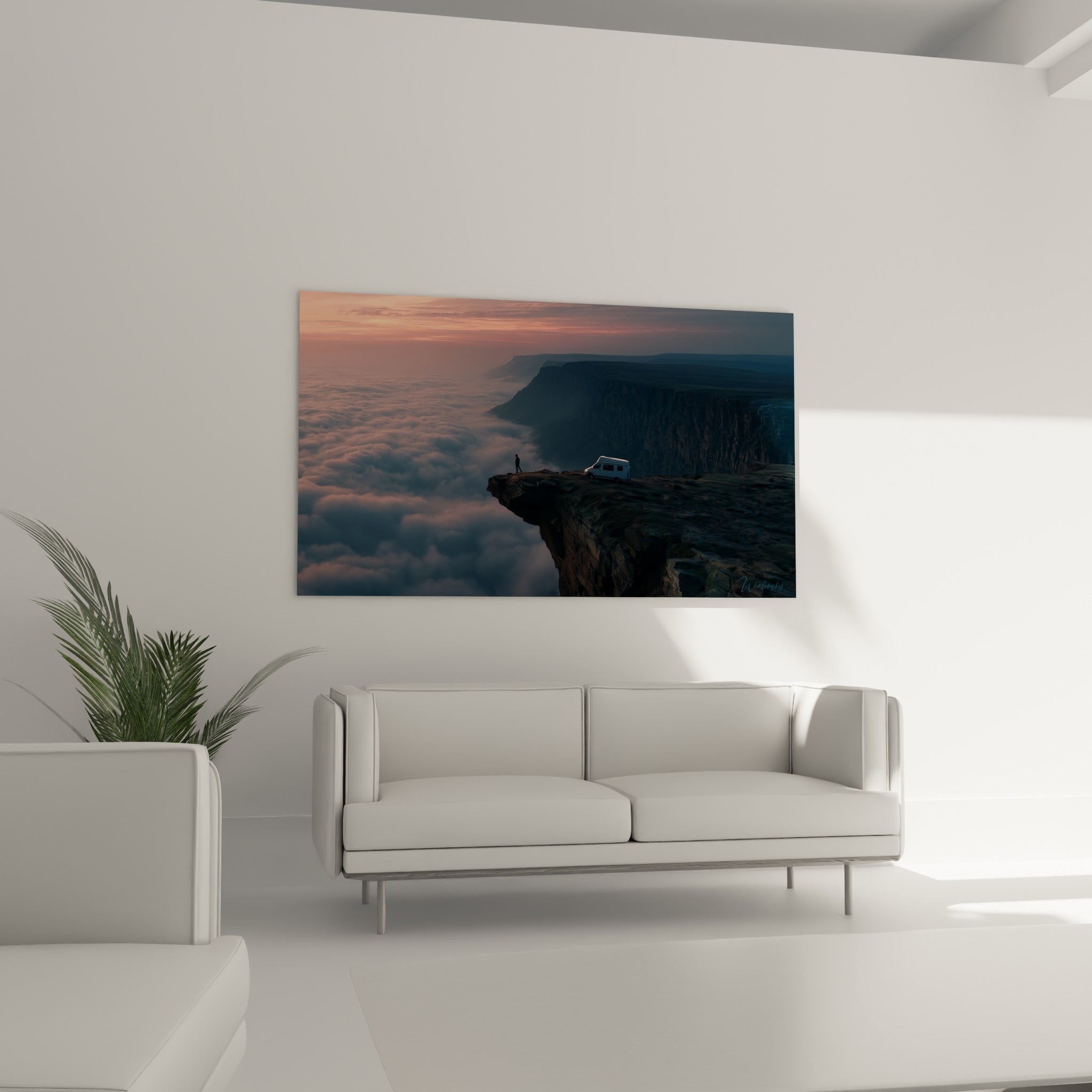 Silhouette face au vide sur roche sombre et nuages roses, tableau au-dessus d'un canapé dans un salon lumineux