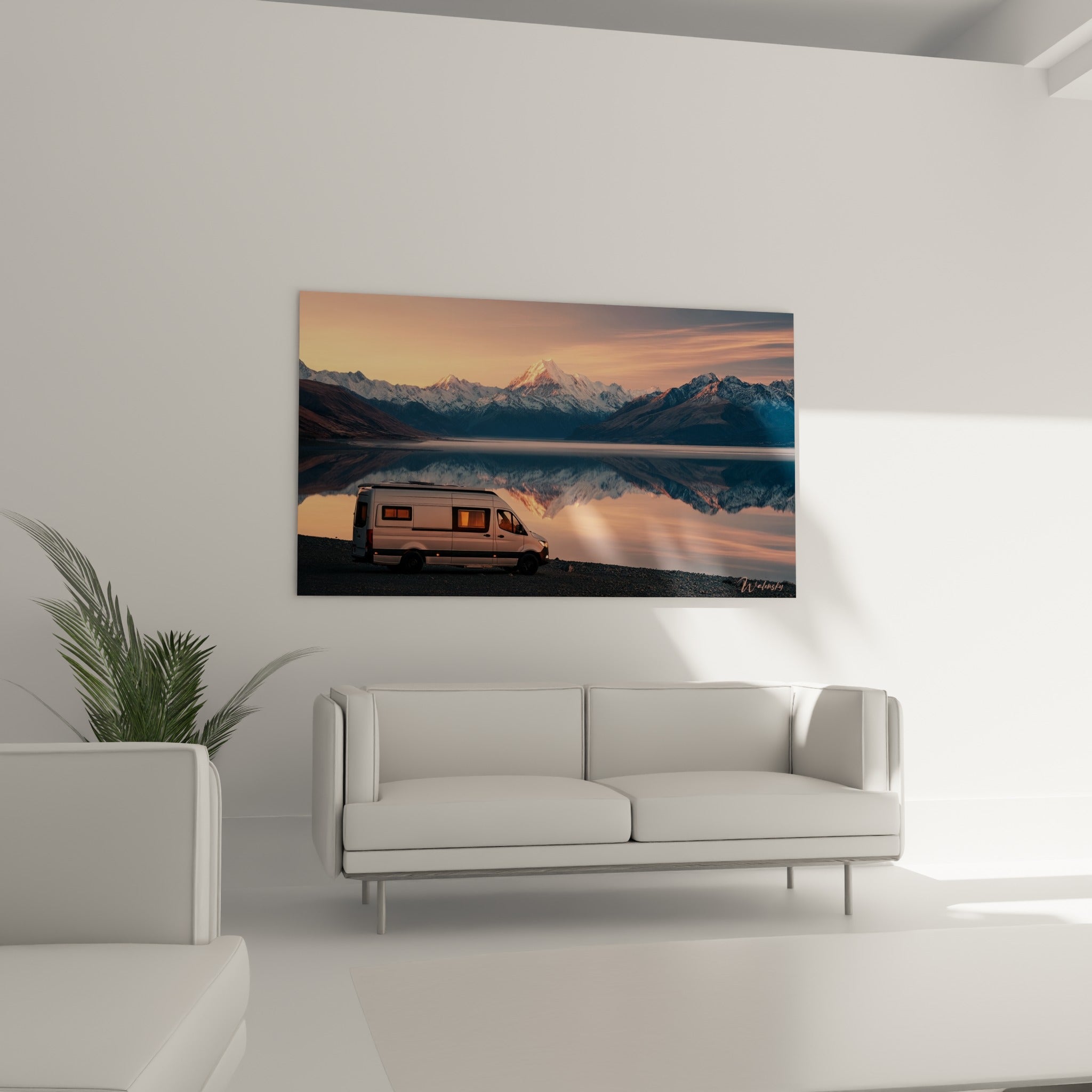 Sommets enneigés et van blanc sous un ciel rose et anthracite, au-dessus d'un canapé dans un salon lumineux
