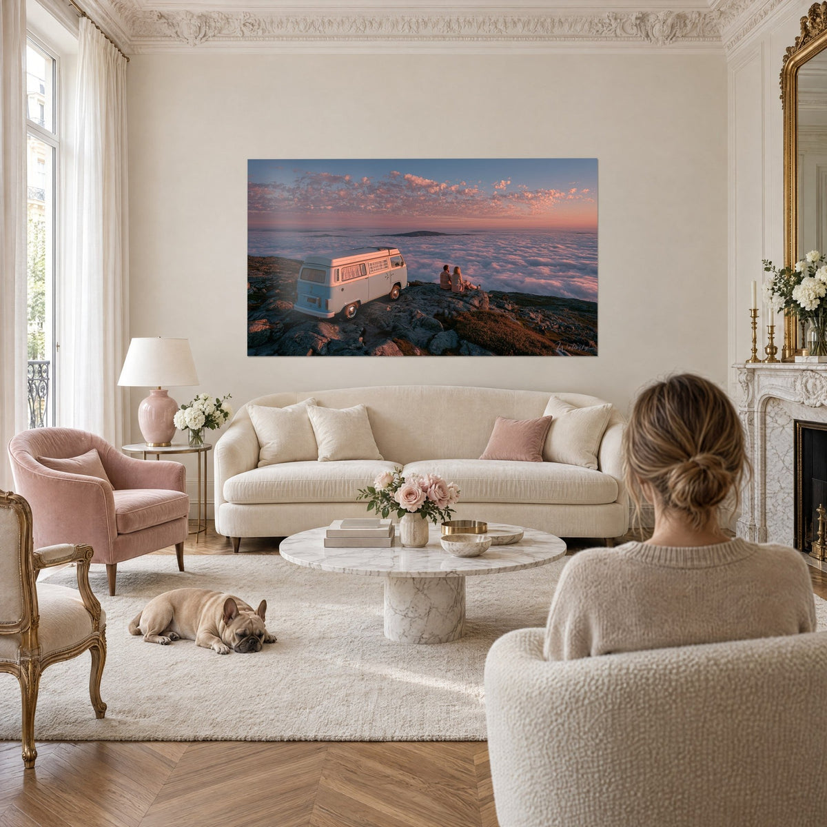Quadro di un camper Volkswagen azzurro e bianco su una roccia, mare di nuvole rosa, sopra un divano in un soggiorno luminoso