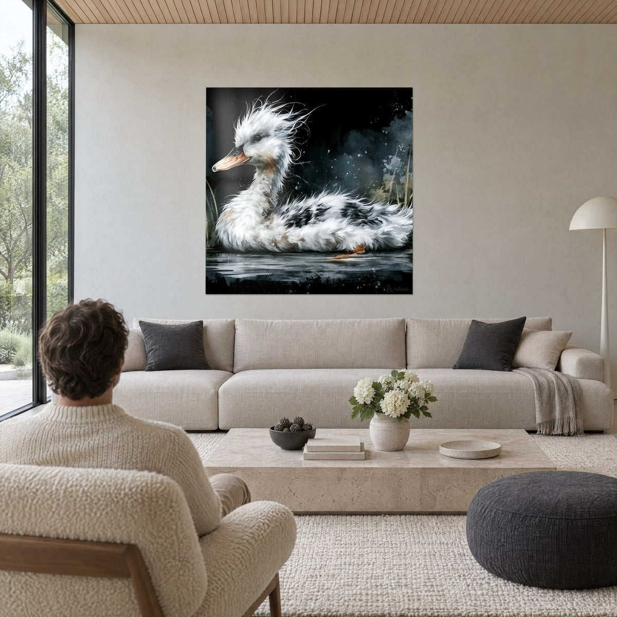 Tableau canard ébouriffé blanc et noir, bec orangé et fond d'encre, au-dessus d'un canapé dans un salon lumineux
