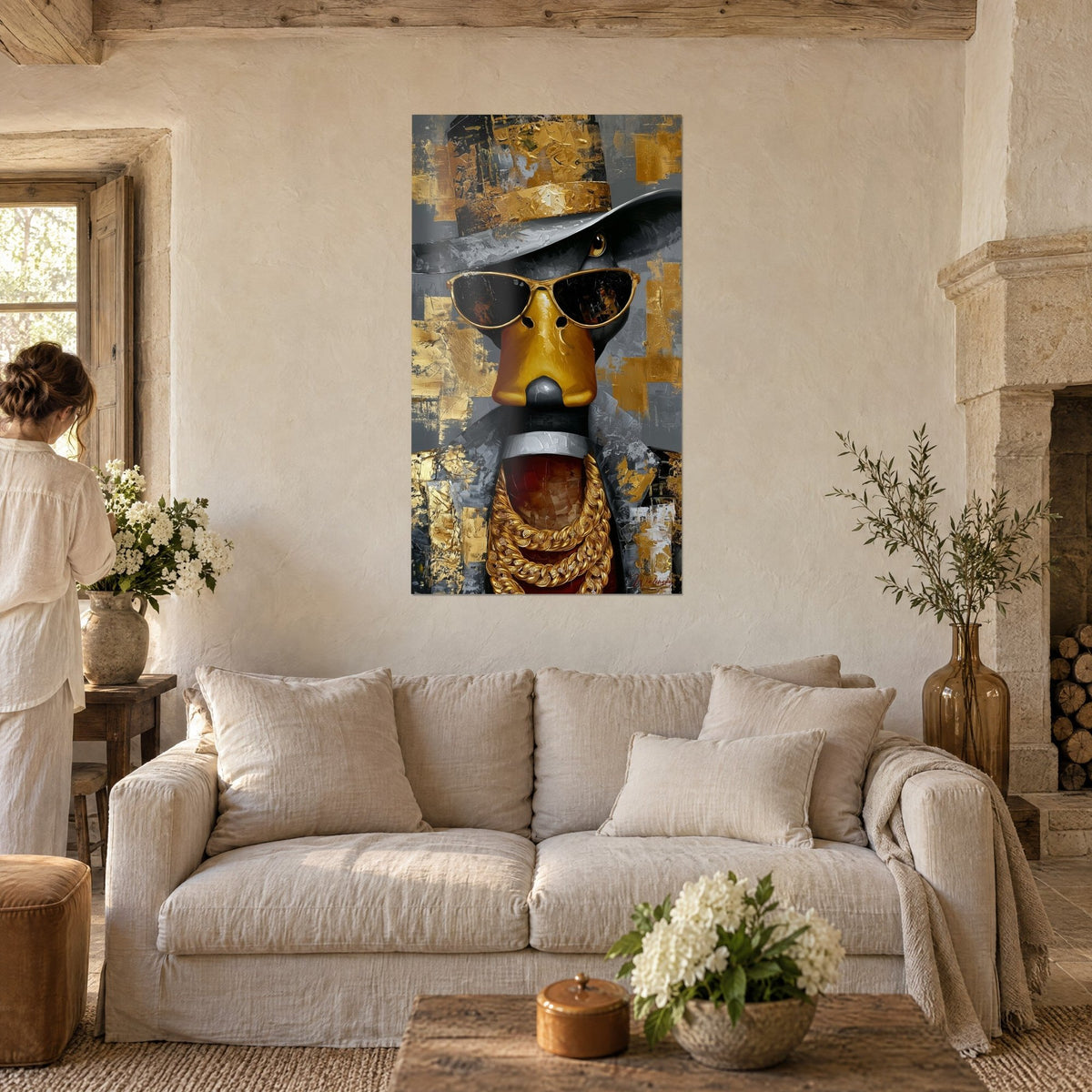 Tableau canard doré en chapeau gris et lunettes noires, touches d'or épaisses, au-dessus d'un canapé dans un salon lumineux