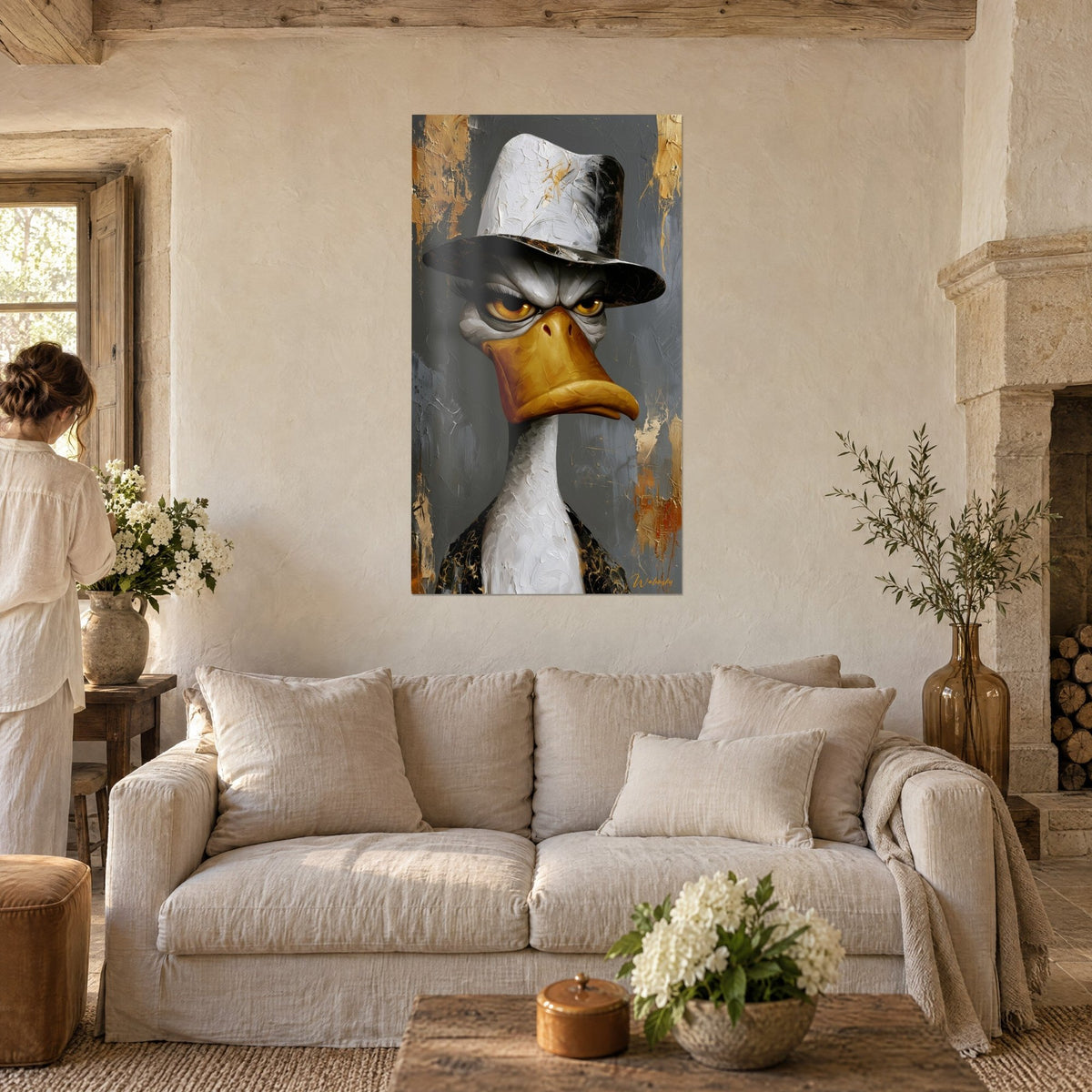 Tableau canard blanc coiffé d'un feutre argenté, bec doré, regard ambre sévère, au-dessus d'un canapé dans un salon lumineux