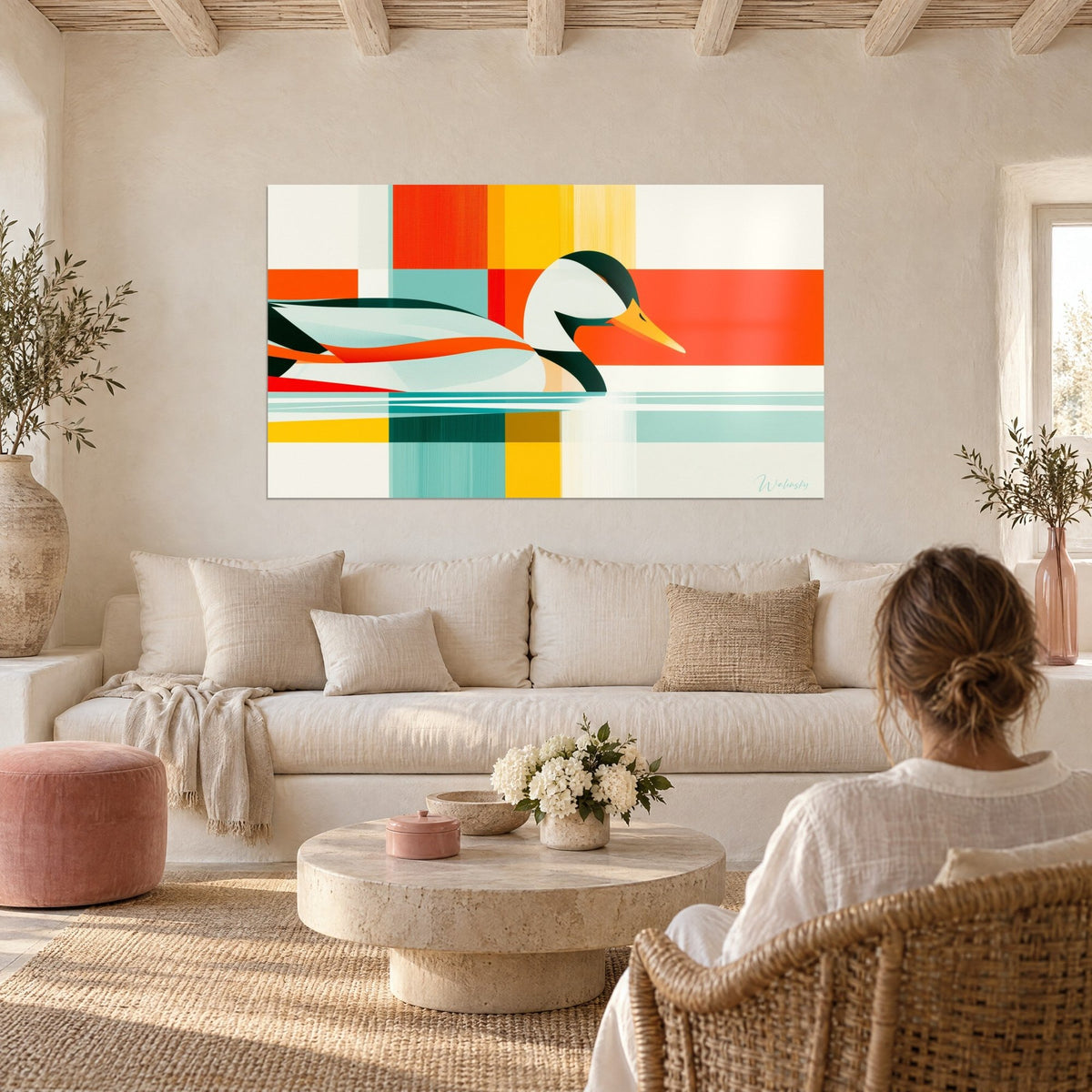 Tableau canard stylisé à bec jaune sur damier orange et turquoise, femme de dos, au-dessus d'un canapé dans un salon lumineux