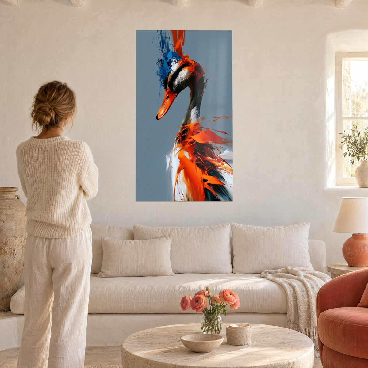 Wall art duck with a vivid orange beak and feathers splashed with cobalt blue, on a grey background, above a sofa in a bright living room