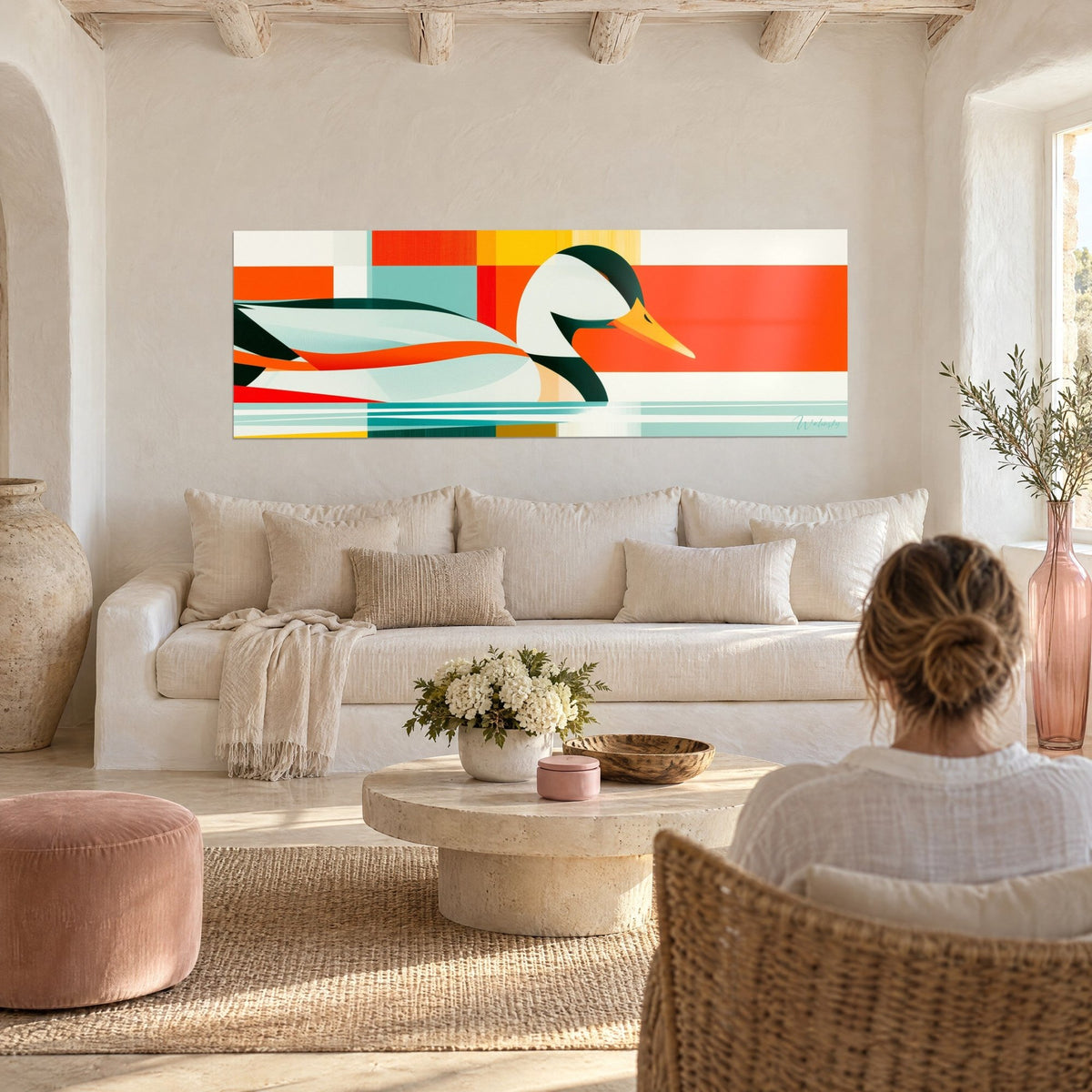 Tableau colvert stylisé au bec orangé sur damier orange, jaune et turquoise, vu par une femme au-dessus d'un canapé dans un salon lumineux