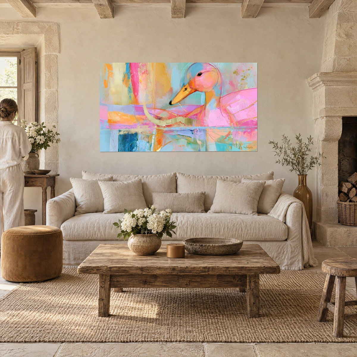 Tableau canard rose au bec orangé sur fond turquoise et or, deux personnes de dos, au-dessus d'un canapé dans un salon lumineux