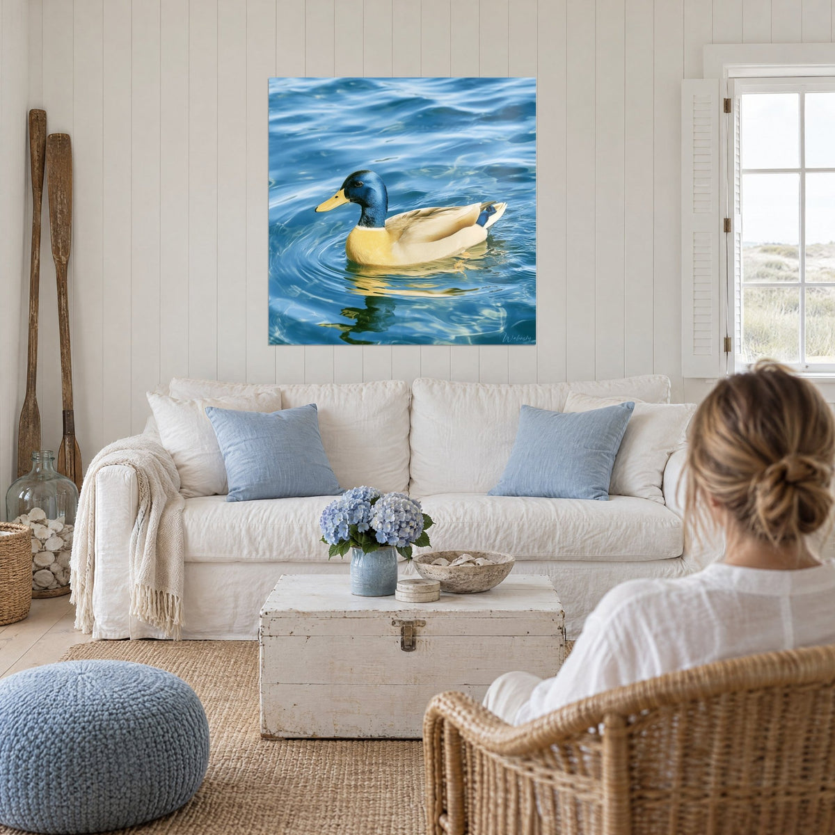 Tableau canard colvert à tête bleu nuit nageant sur l'eau cobalt, ventre doré, au-dessus d'un canapé dans un salon lumineux