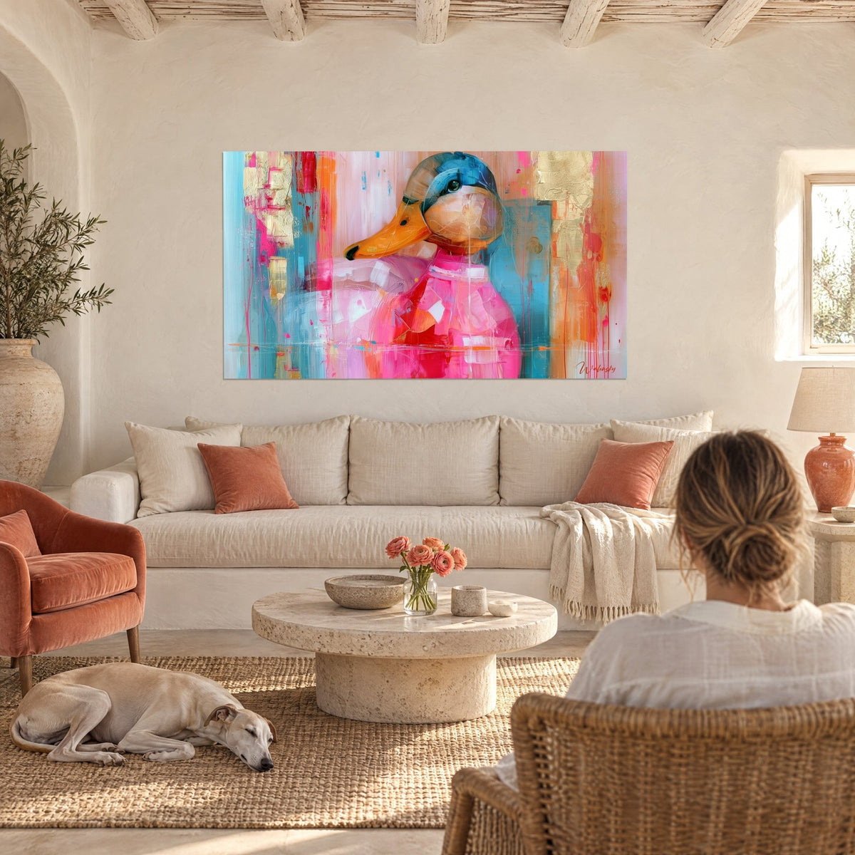 Quadro anatra rosa dal becco arancione, colature blu petrolio e foglia d'oro, vista di spalle, sopra un divano in un soggiorno luminoso
