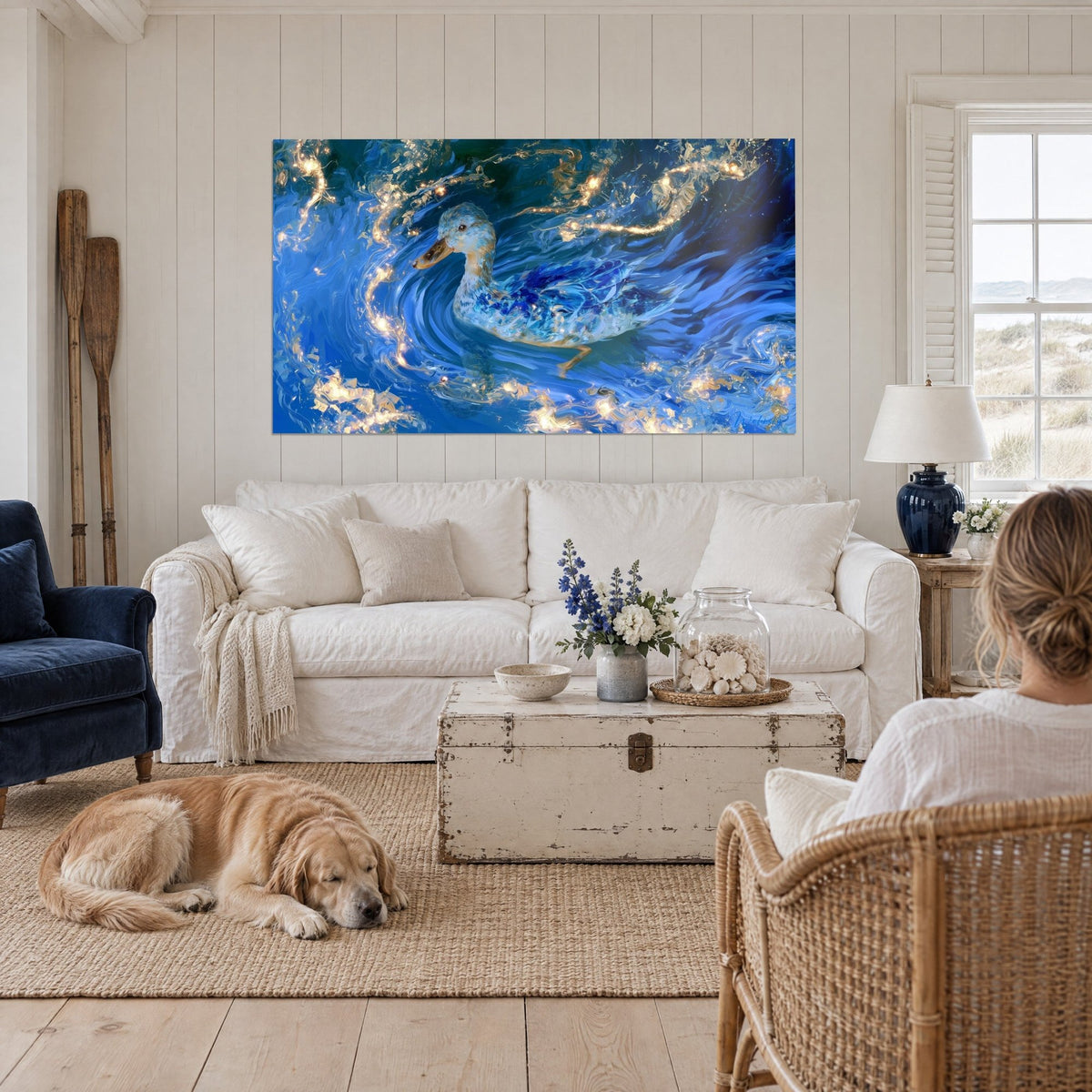Tableau canard nageant dans des remous cobalt et ocre doré, une femme de dos et un retriever, au-dessus d'un canapé dans un salon lumineux