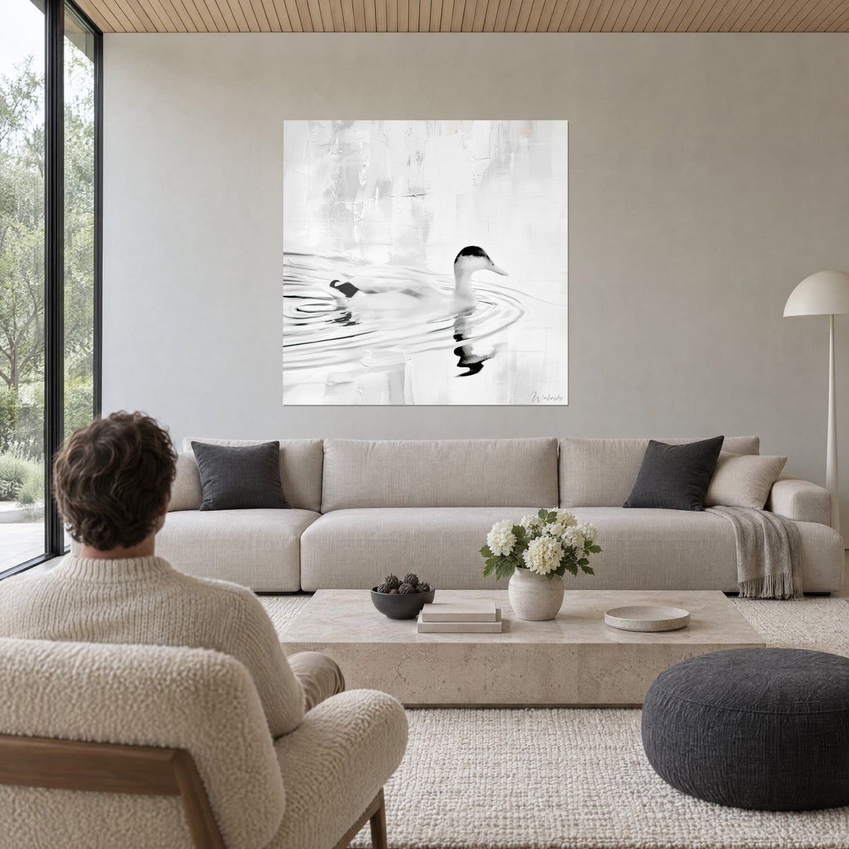 Cuadro pato blanco deslizándose sobre agua gris, cresta negra, ondas concéntricas, encima de un sofá en un salón luminoso