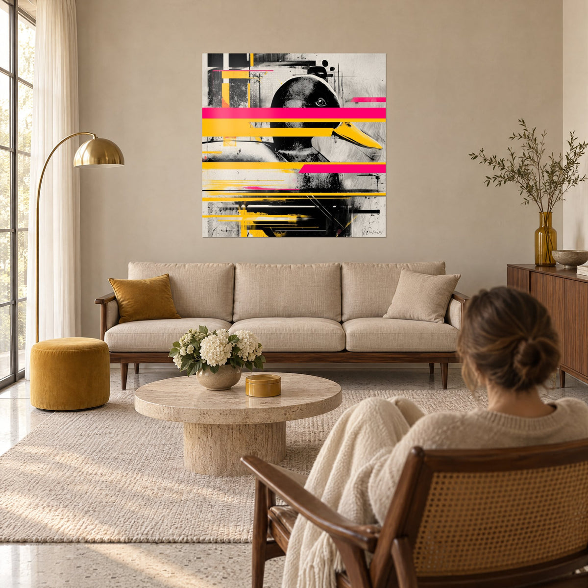 Tableau canard de profil au bec jaune, bandes roses et jaunes sur fond crème, au-dessus d'un canapé dans un salon lumineux