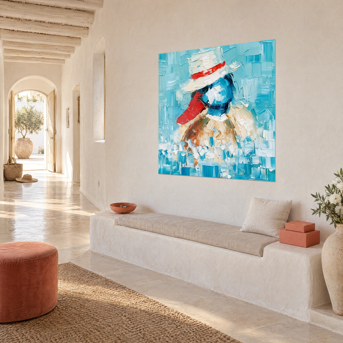 Quadro volatile con panama color crema, fascia rosso vivo, piumaggio blu oltremare, tocchi turchesi, parete bianca, casa mediterranea