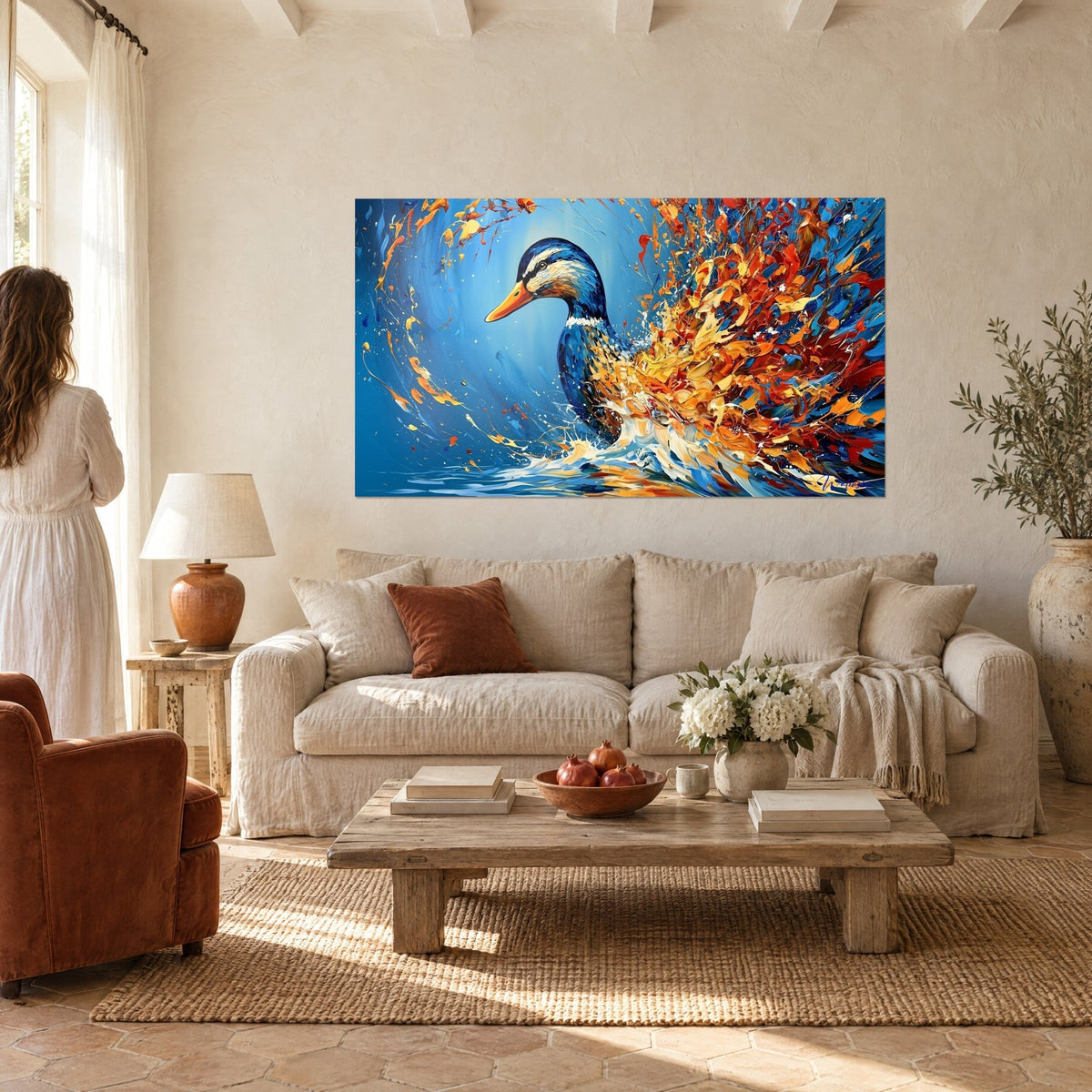 Tableau canard colvert bleu cobalt jaillissant d'une gerbe de plumes orange et rouges, au-dessus d'un canapé dans un salon lumineux