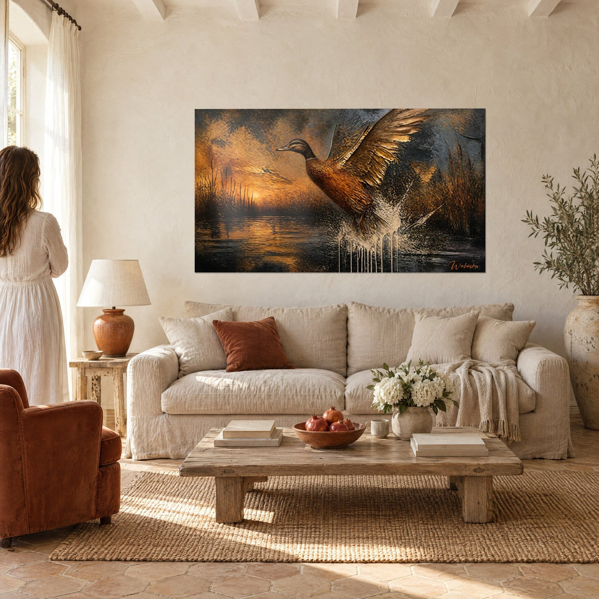 Quadro germano reale con le ali spiegate su una palude color rame e nera, sole arancione, donna di spalle sopra un divano in un soggiorno luminoso