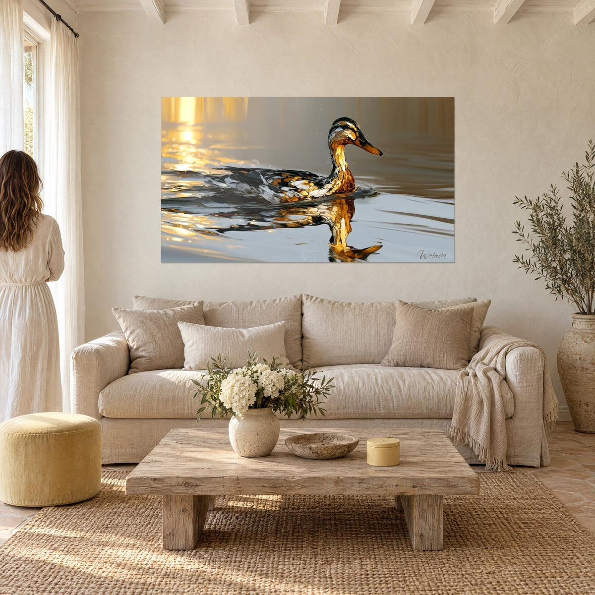 Tableau canard colvert aux plumes ocre et noires glissant sur l'eau argentée, reflet doré, au-dessus d'un canapé dans un salon lumineux