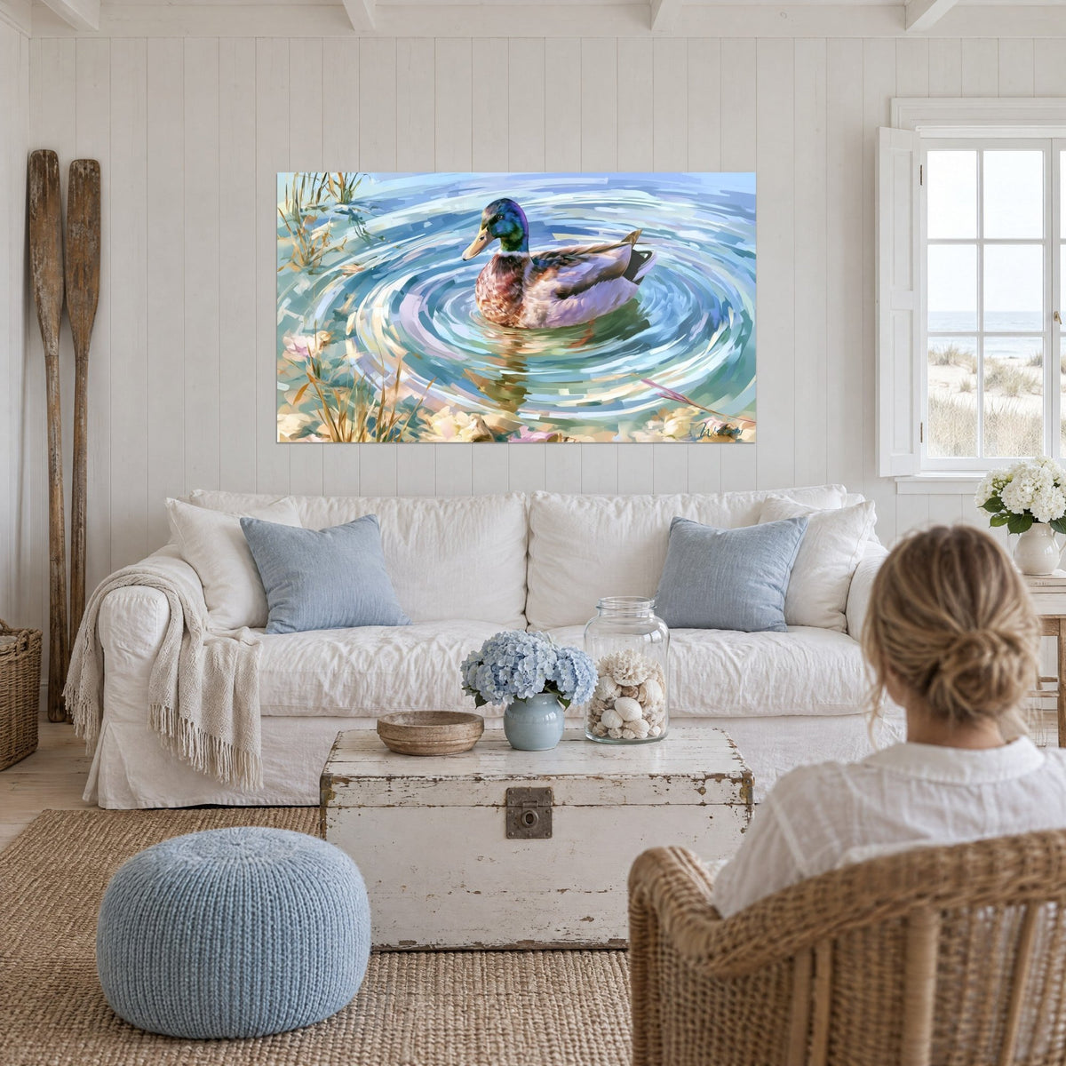 Tableau colvert à tête vert émeraude nageant dans des ondes bleues et lavande, au-dessus d'un canapé dans un salon lumineux