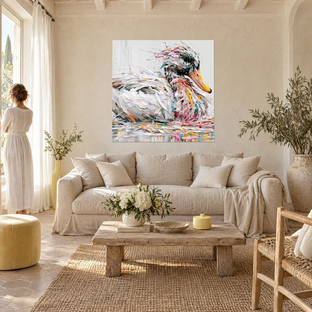 Tableau canard blanc au bec doré, plumes en empâtements rose et turquoise, au-dessus d'un canapé dans un salon lumineux