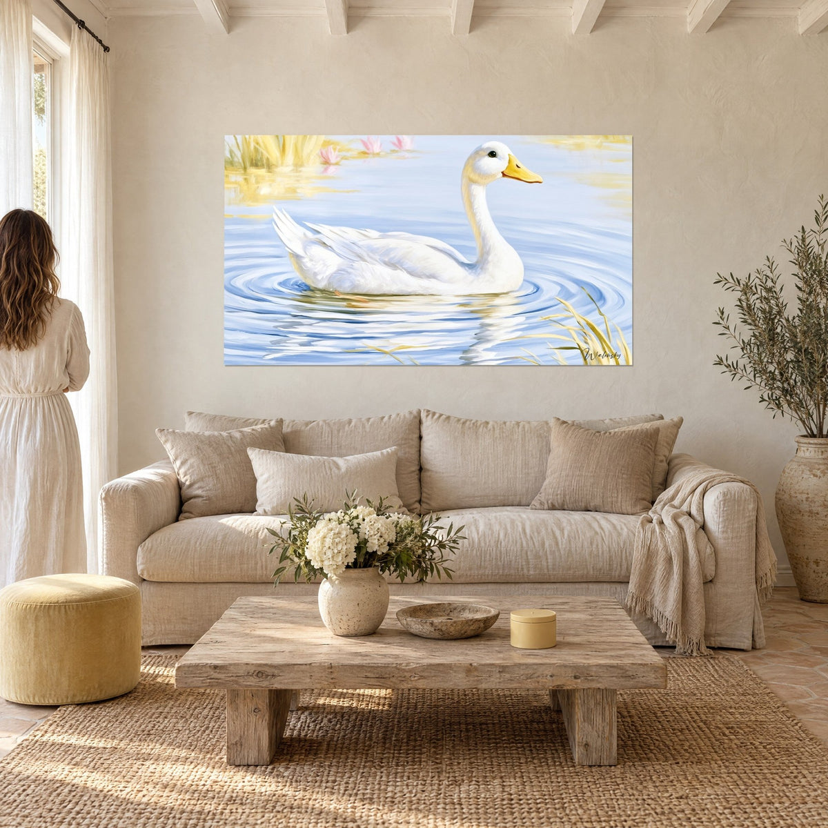 Tableau palmipède immaculé glissant sur l'eau bleu ciel, bec jaune, nénuphars roses, au-dessus d'un canapé dans un salon lumineux
