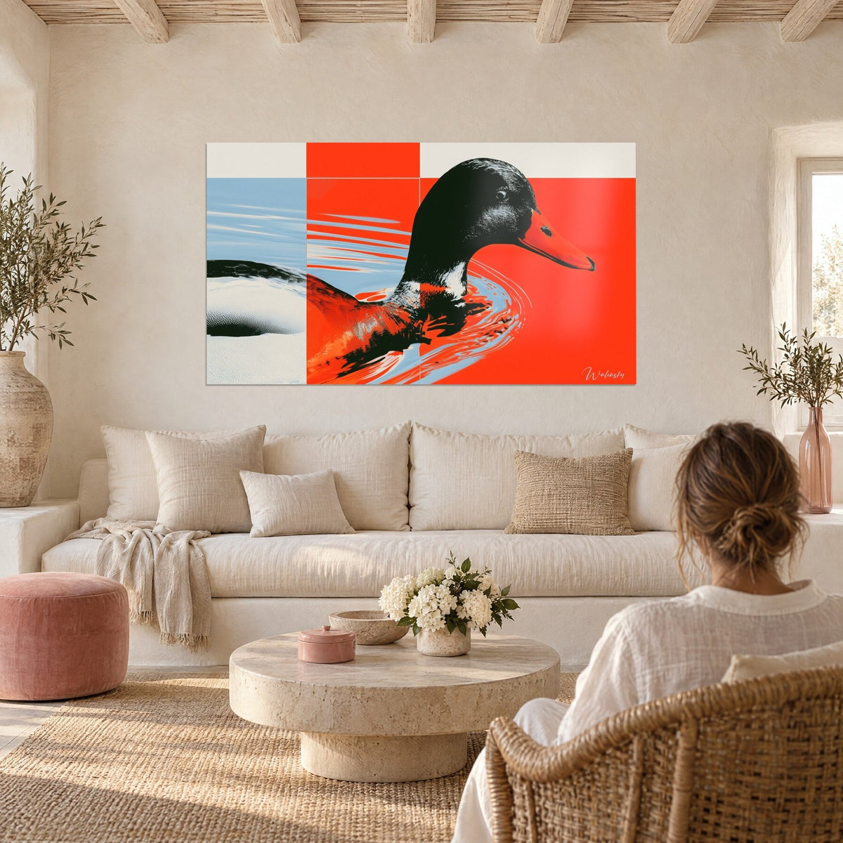 Tableau canard colvert à tête noire et bec orange nageant sur fond rouge vermillon et bleu pâle, au-dessus d'un canapé dans un salon lumineux
