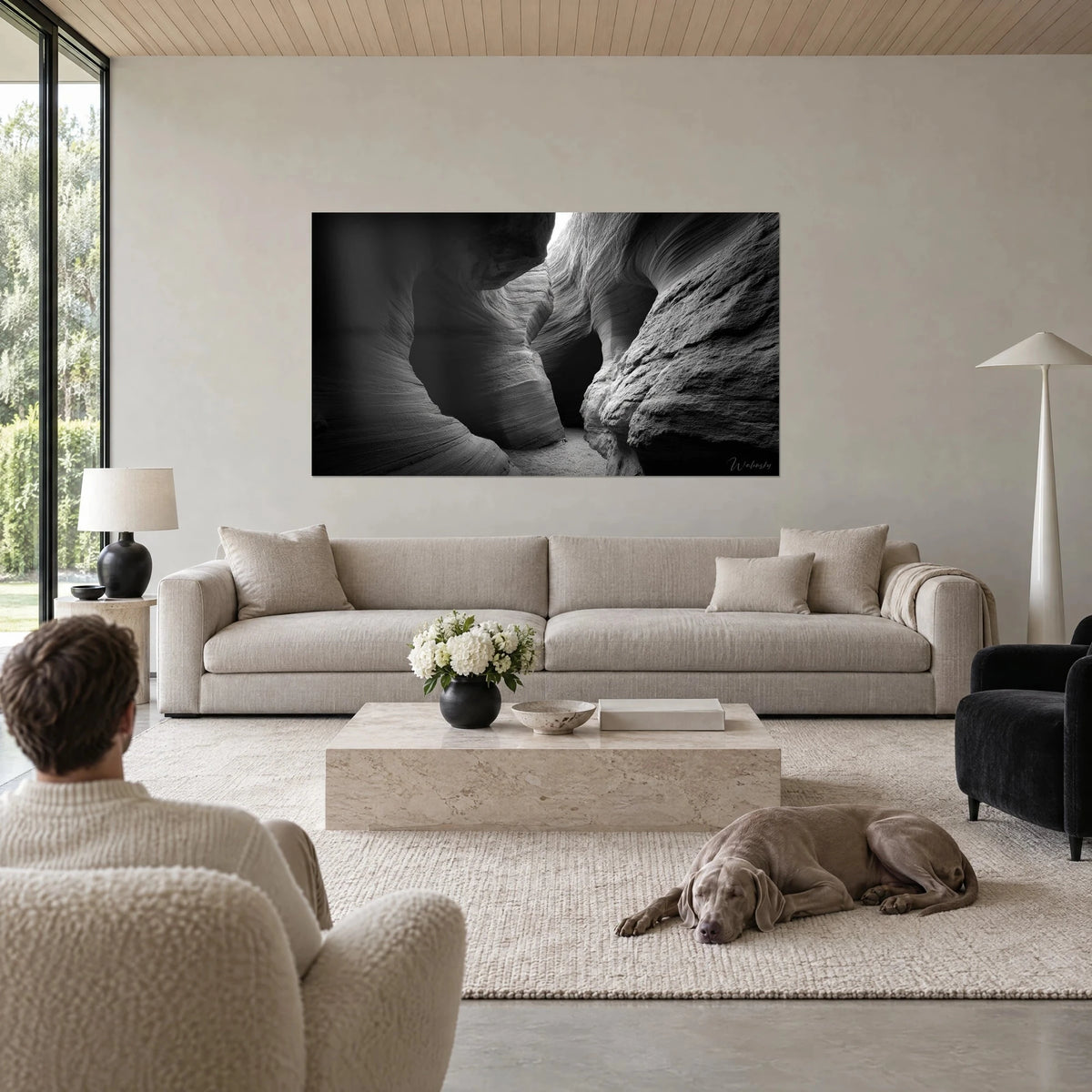 Tableau canyon de grès sculpté en noir et blanc, parois lisses grises et ombres noires, au-dessus d'un canapé dans un salon lumineux