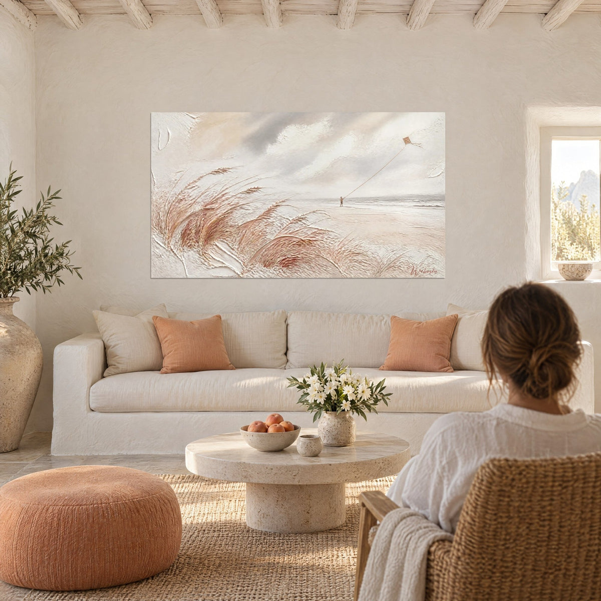 Wall art child flying his kite on the dune, white ochre and powdered pink, grey sky, above a sofa in a bright living room