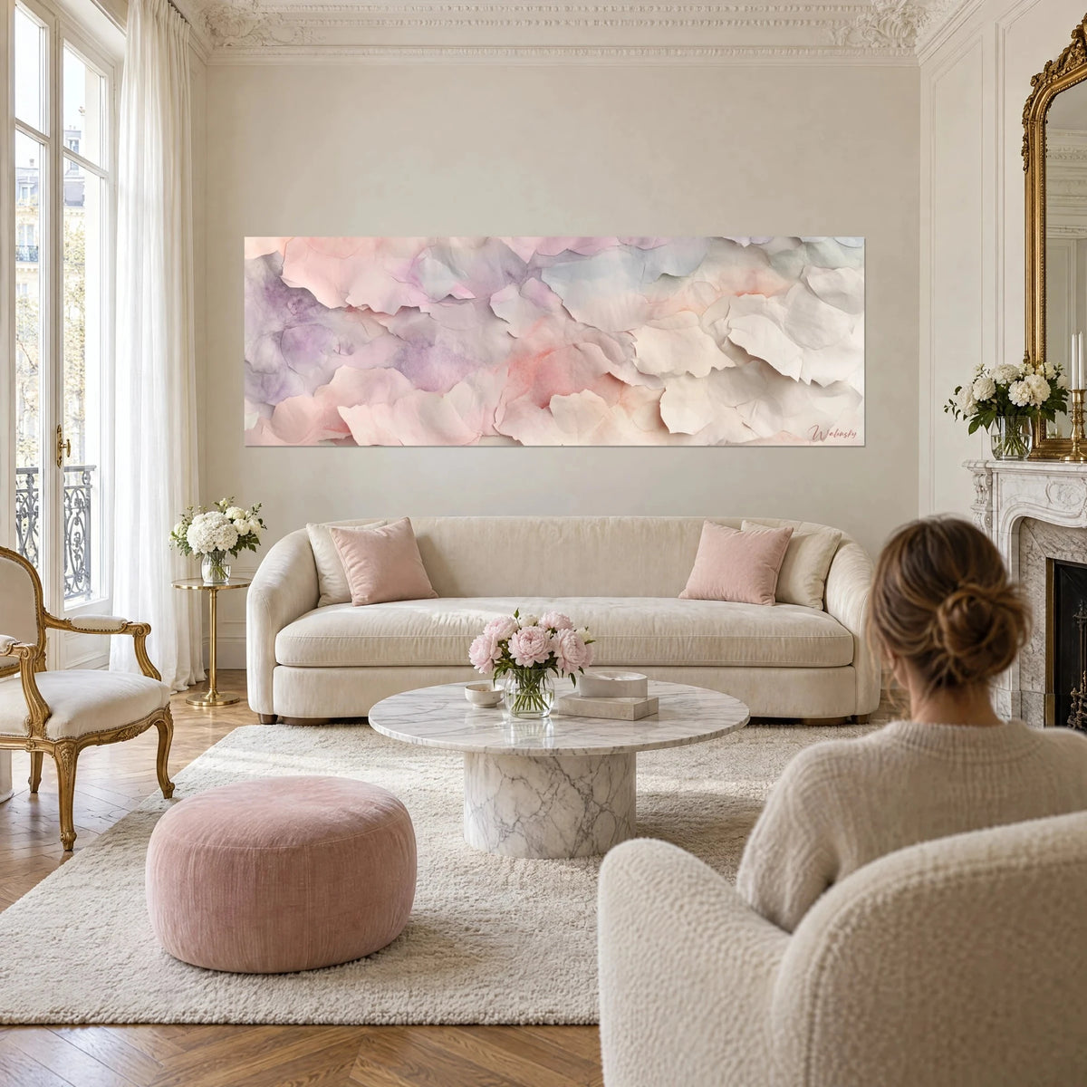 Wall art with crumpled paper petals in powder pink and lilac, panoramic, couple seen from behind above a sofa in a bright living room