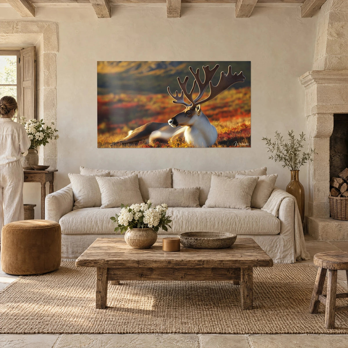 Wall art majestic caribou with velvet brown antlers, russet and gold tundra, above a sofa in a bright living room