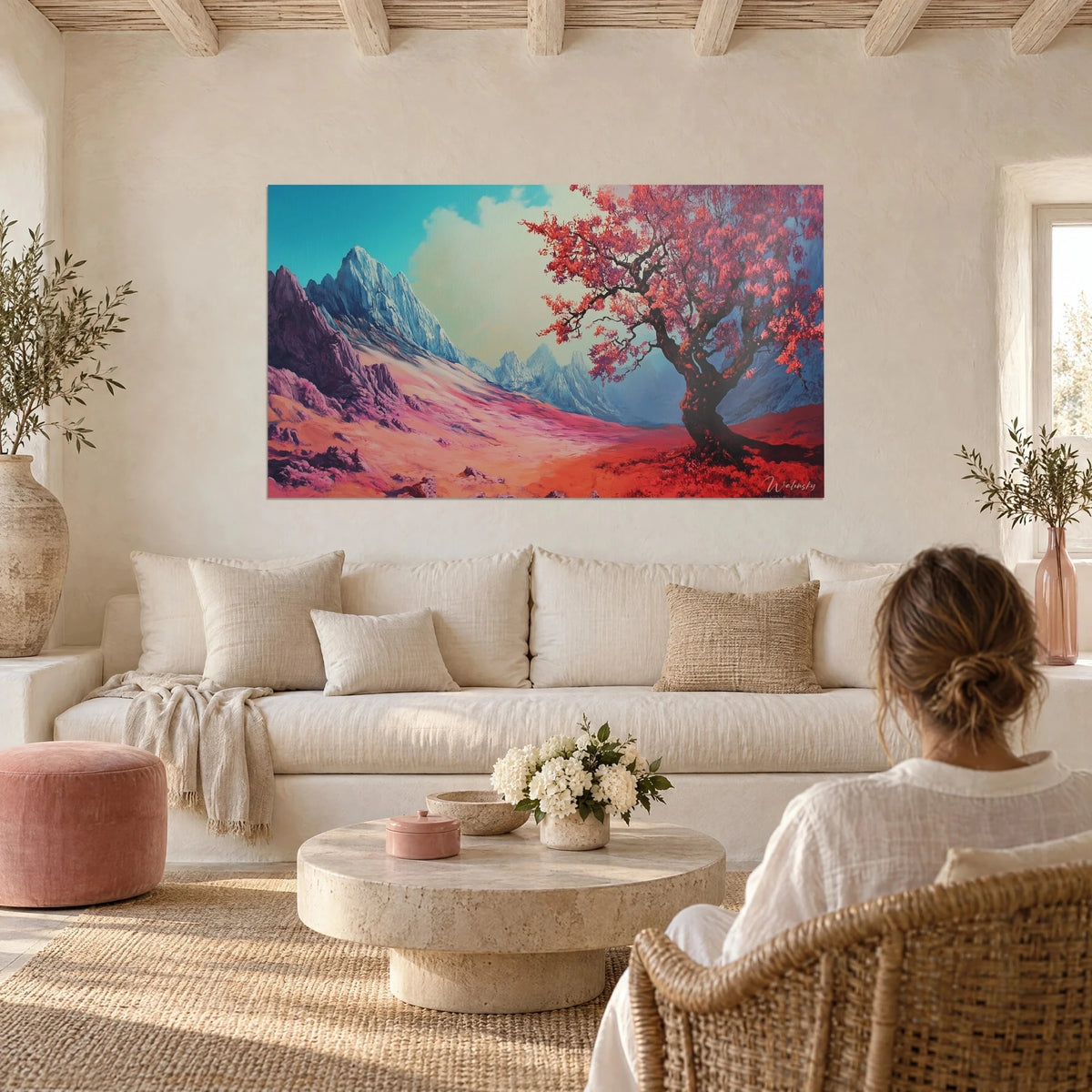 Gemälde mit Kirschbaum mit karminroten Blättern vor bläulichen Gipfeln, über einem Sofa in einem hellen Wohnzimmer