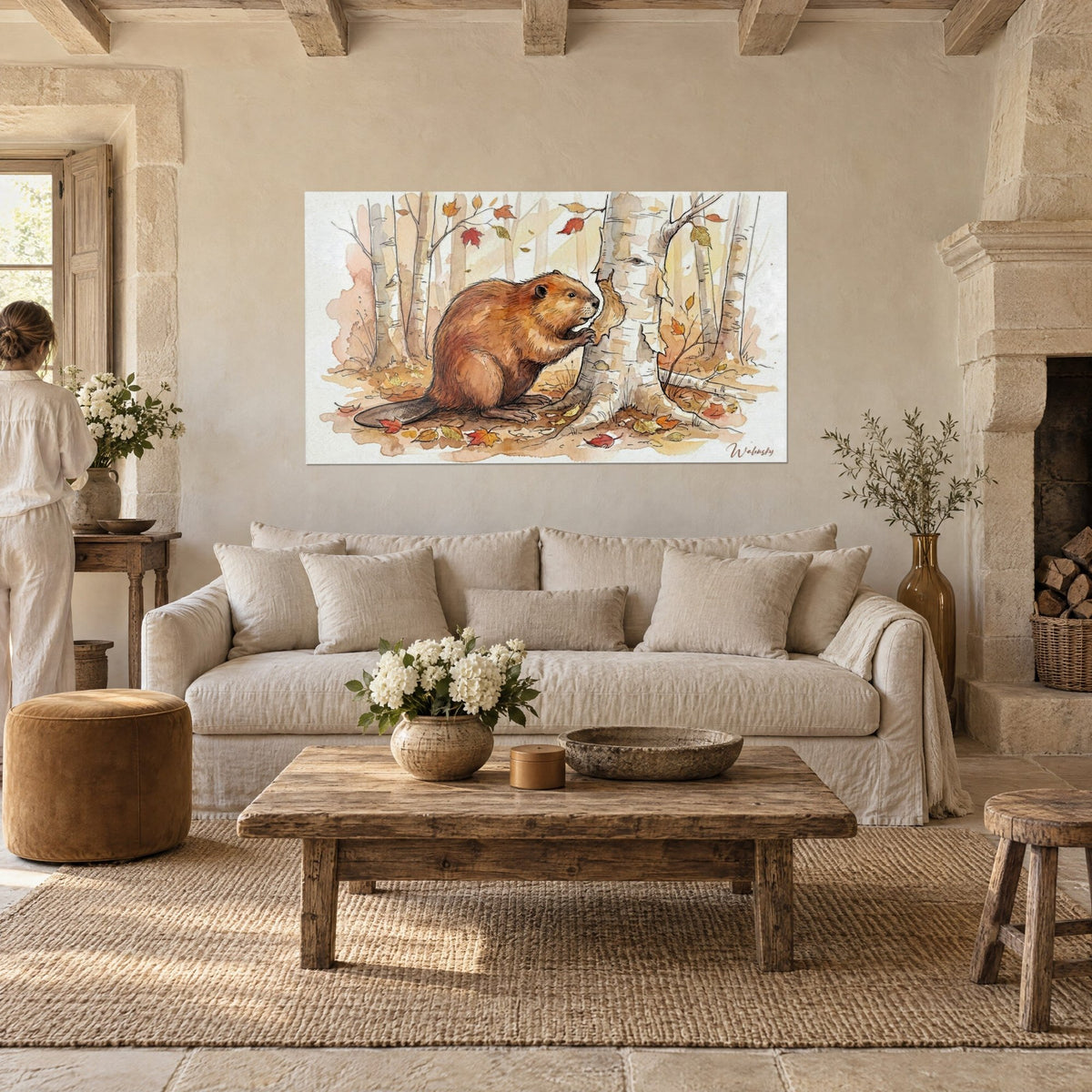 Wall art russet beaver gnawing a white birch, red and ochre maple leaves, above a sofa in a bright living room