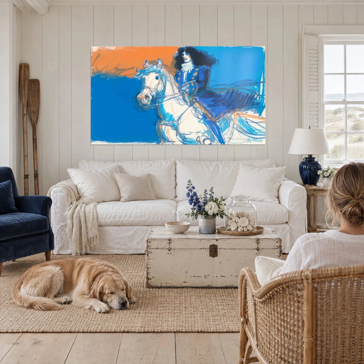 Tableau cavalier en justaucorps bleu sur cheval blanc, fond orange et azur, au-dessus d'un canapé dans un salon lumineux