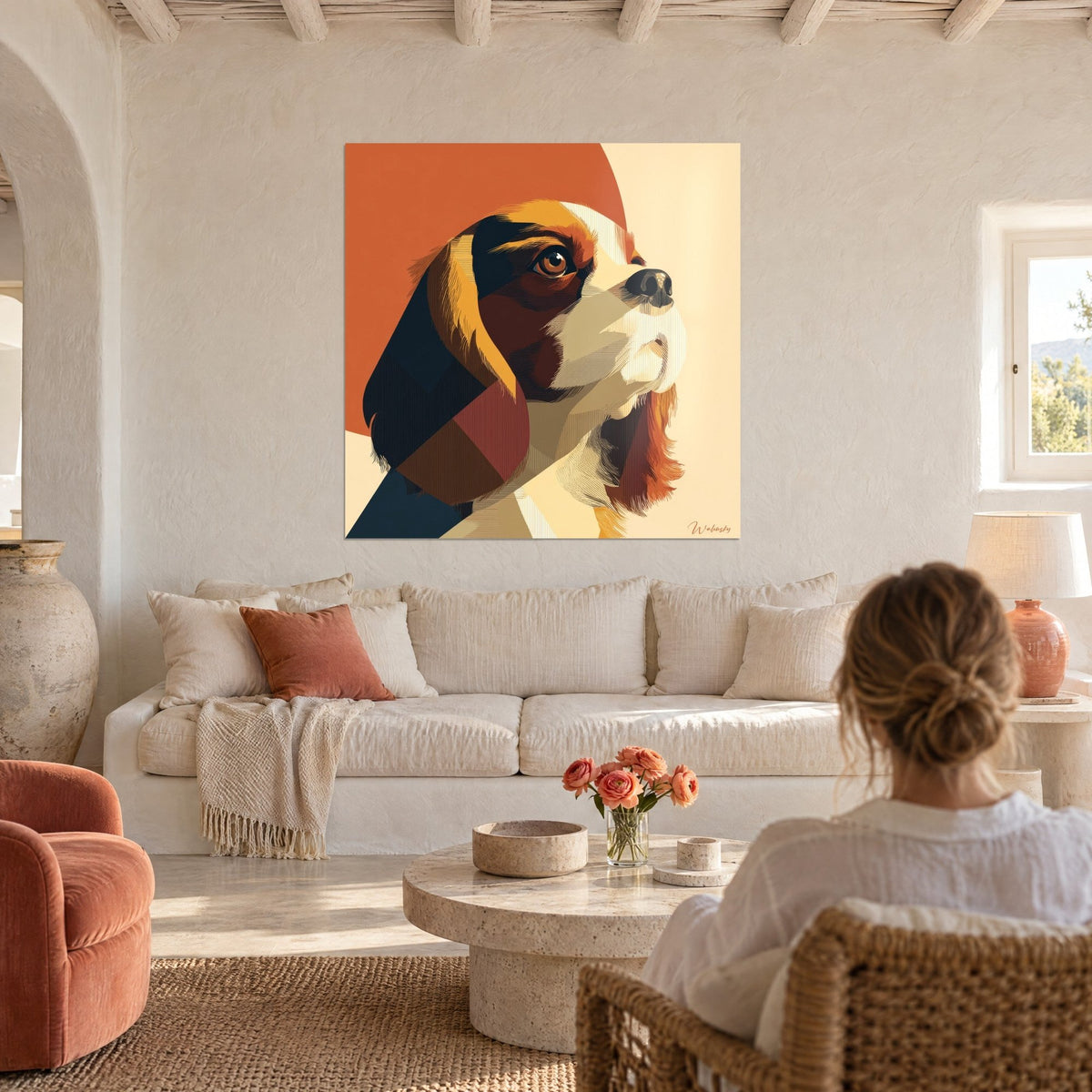 Cuadro spaniel tricolor con mirada levantada, planos naranja quemado y crema, encima de un sofá en un salón luminoso