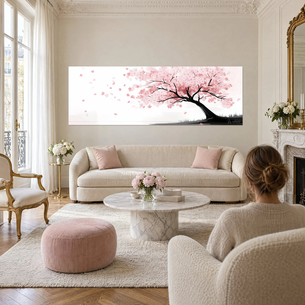 Gemälde Kirschbaum in zartrosa Blüte, schwarzer geneigter Stamm, fliegende Blütenblätter auf weißem Grund, über einem Sofa in einem hellen Wohnzimmer