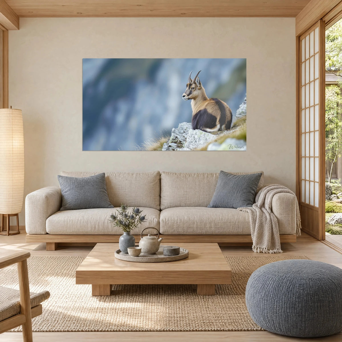 Gemälde Gämse mit schwarzen Hörnern, fahlbraunes Fell und dunkelbrauner Rücken auf grauem Fels, über einem Sofa in einem hellen Wohnzimmer