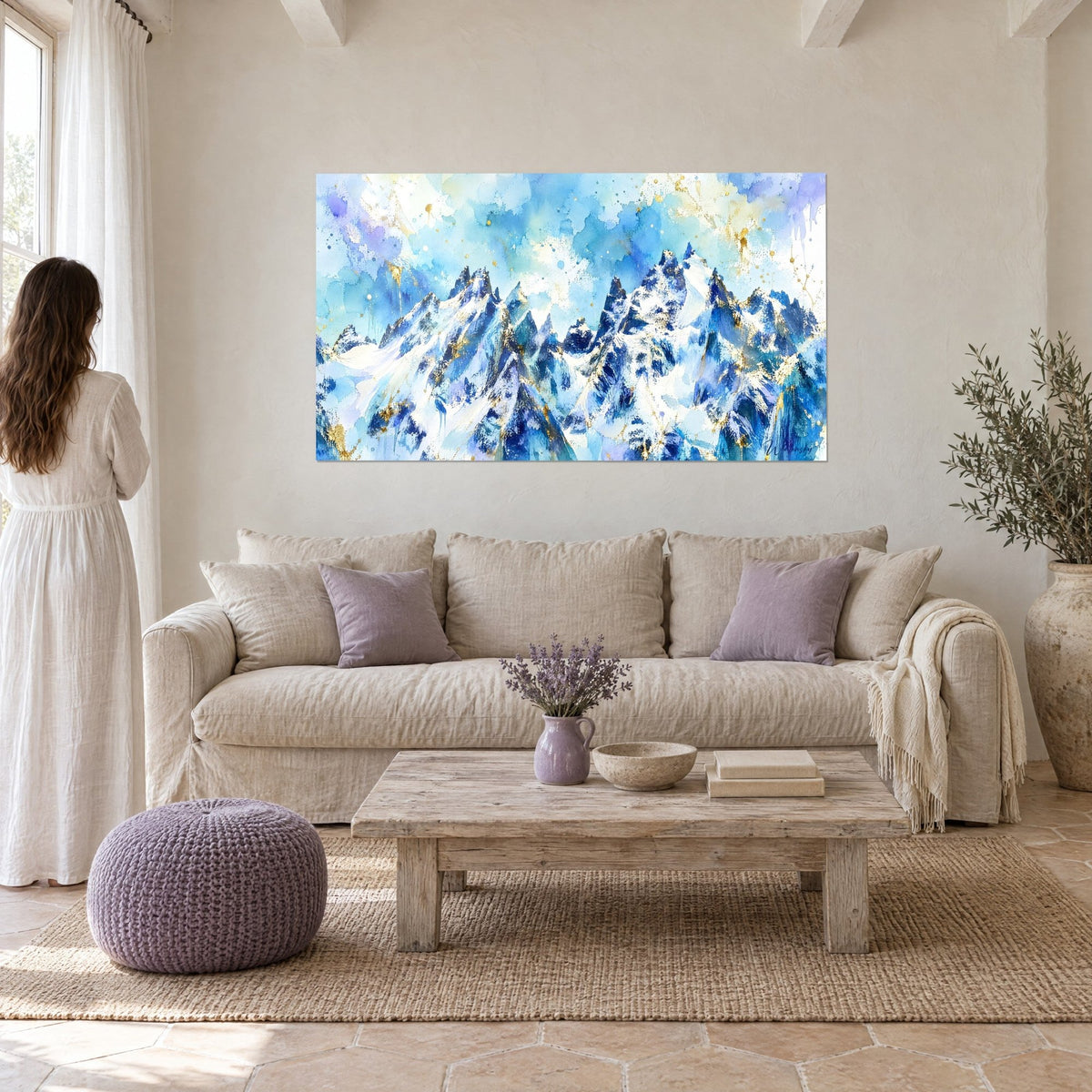 Cuadro picos nevados en acuarela azul celeste y blanco, salpicaduras doradas, sobre un sofá en un salón luminoso