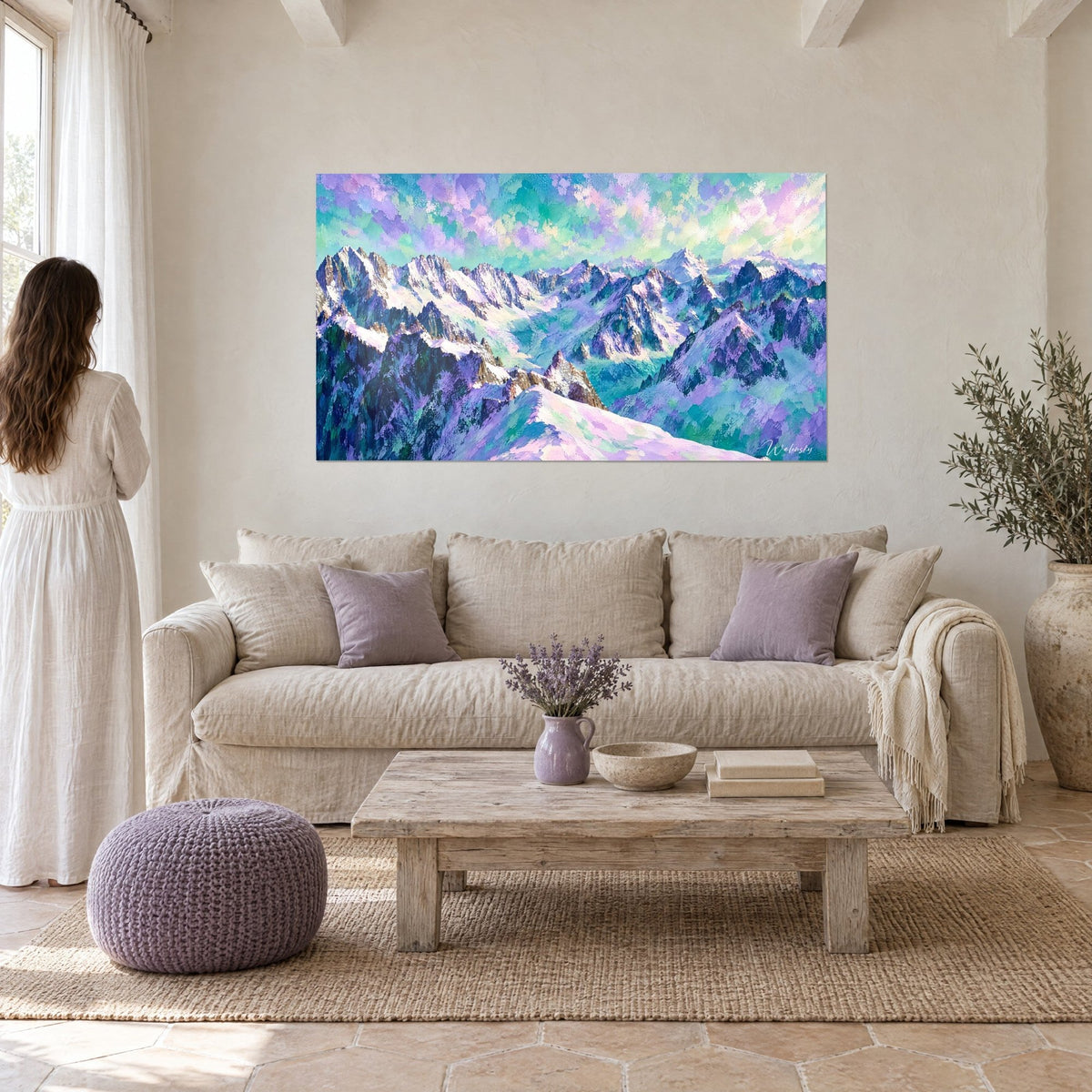 Tableau massif enneigé aux crêtes lilas et turquoise, coups de pinceau épais, femme de dos, au-dessus d'un canapé dans un salon lumineux
