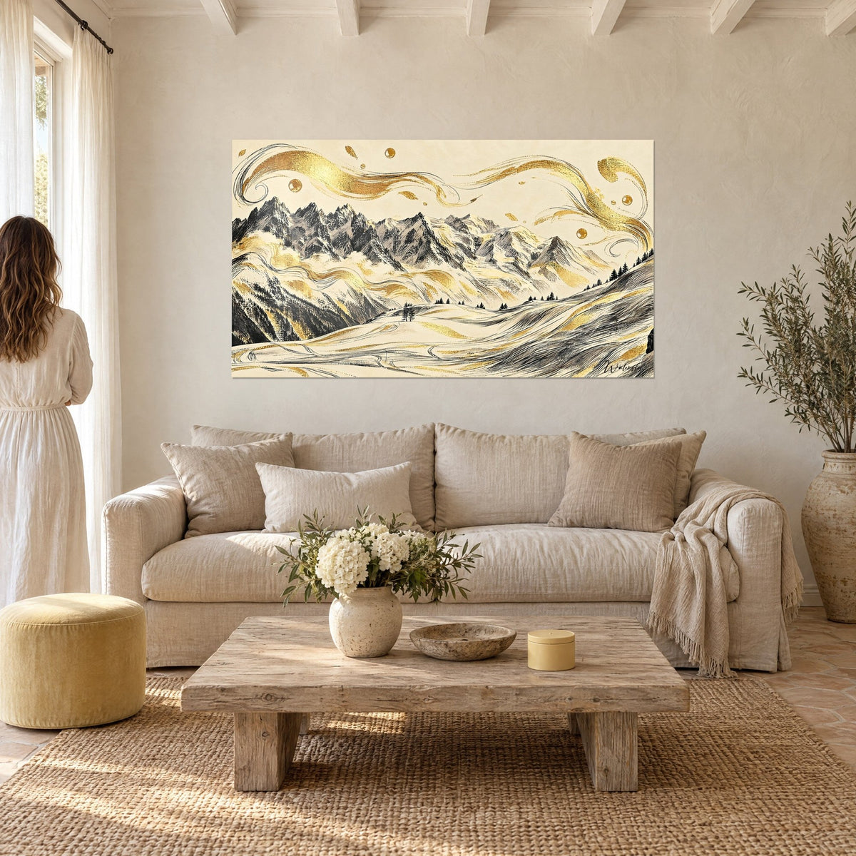 Wall art of an alpine massif in black ink line and golden swirls on cream background, two people seen from behind, above a sofa in a bright living room