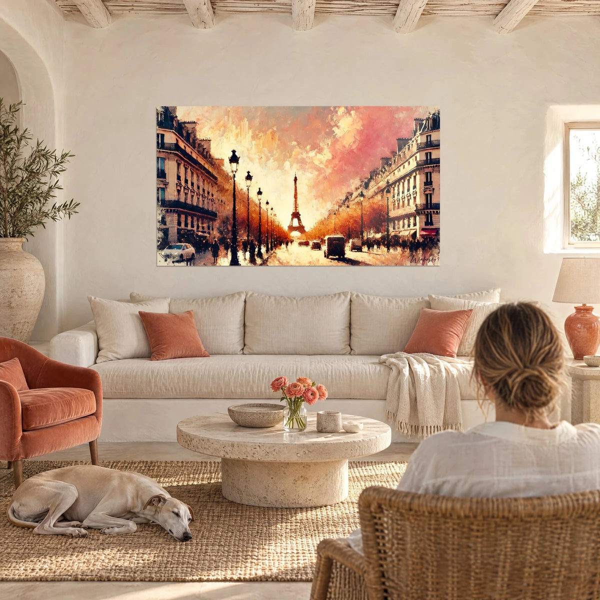 Wall art of a Haussmann-style Parisian avenue under a pink and orange sky, Eiffel Tower in the distance, above a sofa in a bright living room