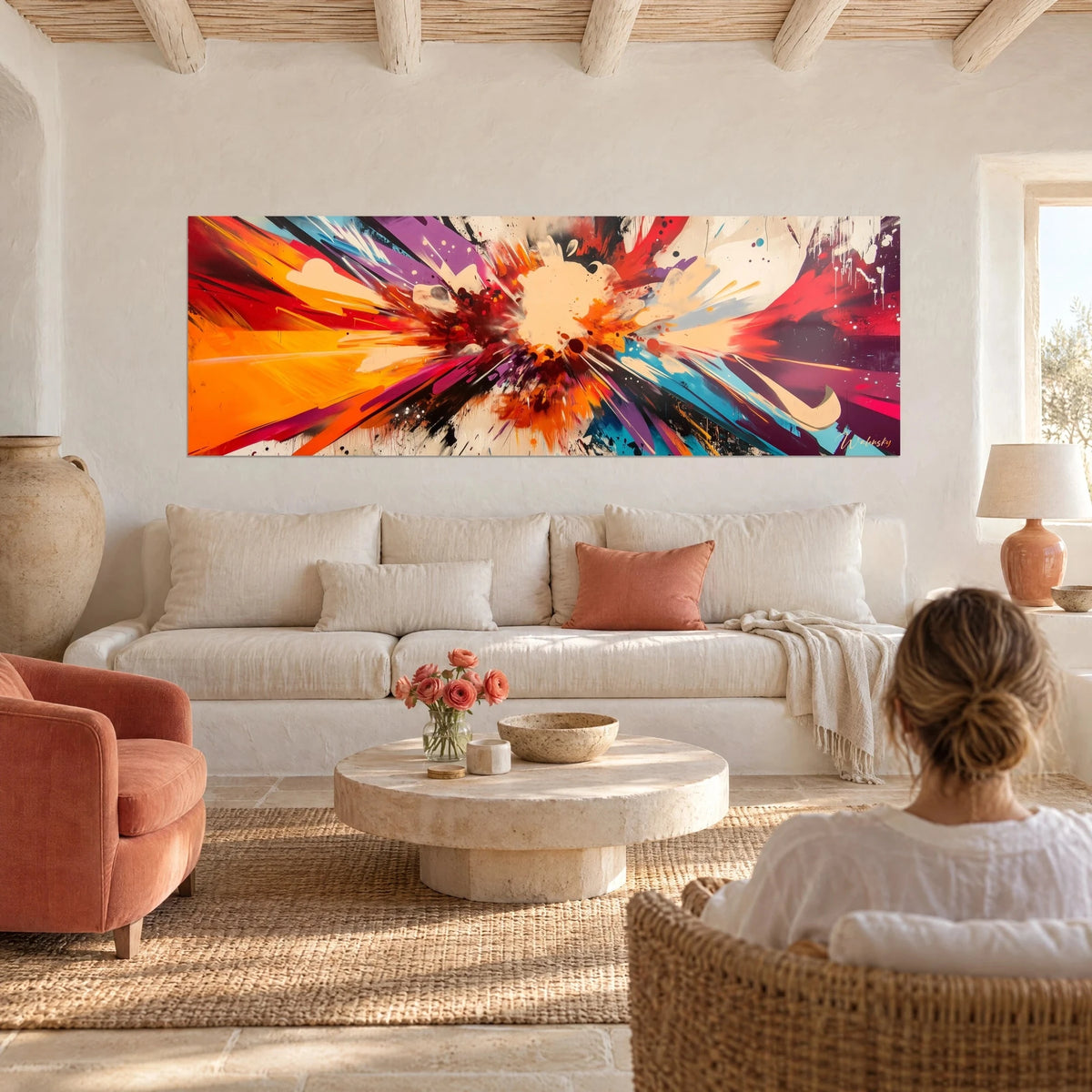 Tableau explosion de peinture orange et violette, éclaboussures crème au centre, femme de dos, au-dessus d'un canapé dans un salon lumineux