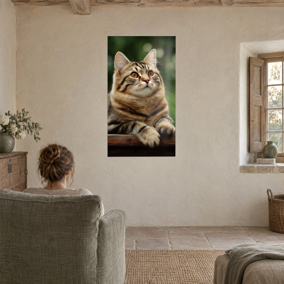 Wall art cat with upright ears and white whiskers, red and brown coat, green background, facing a woman seen from behind in an armchair