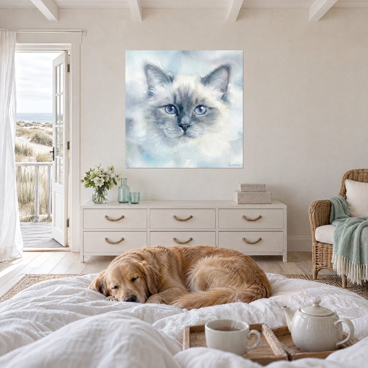 Cuadro carita de Birmano con bigotes blancos, pelaje marfil y máscara azul grisácea, encima de una cama en un dormitorio luminoso
