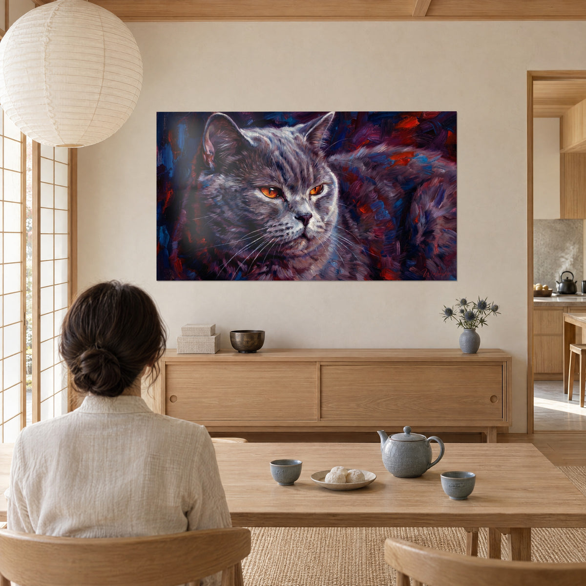 Tableau chartreux au museau rose pâle, pelage gris peint en larges empâtements rouges et bleus, face à une femme de dos, salon japandi