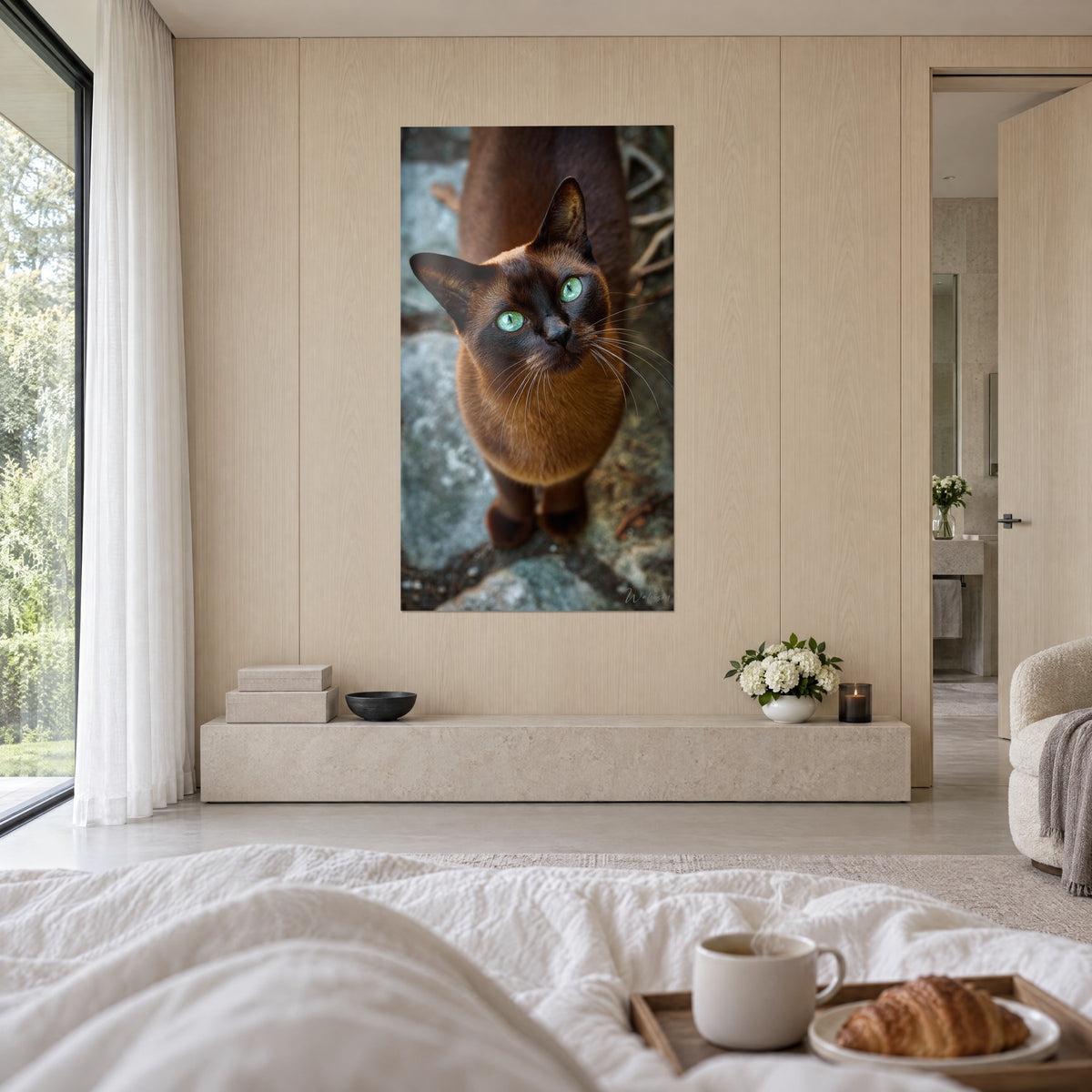 Schilderij Burmese kitten met smaragdgroene ogen, zijdezachte bruine vacht en blauwige steen, boven een bed in een lichte slaapkamer