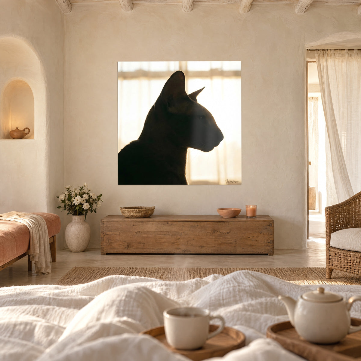 Cuadro felino oscuro de perfil esbelto, cortinas doradas al fondo, encima de una cama en un dormitorio luminoso