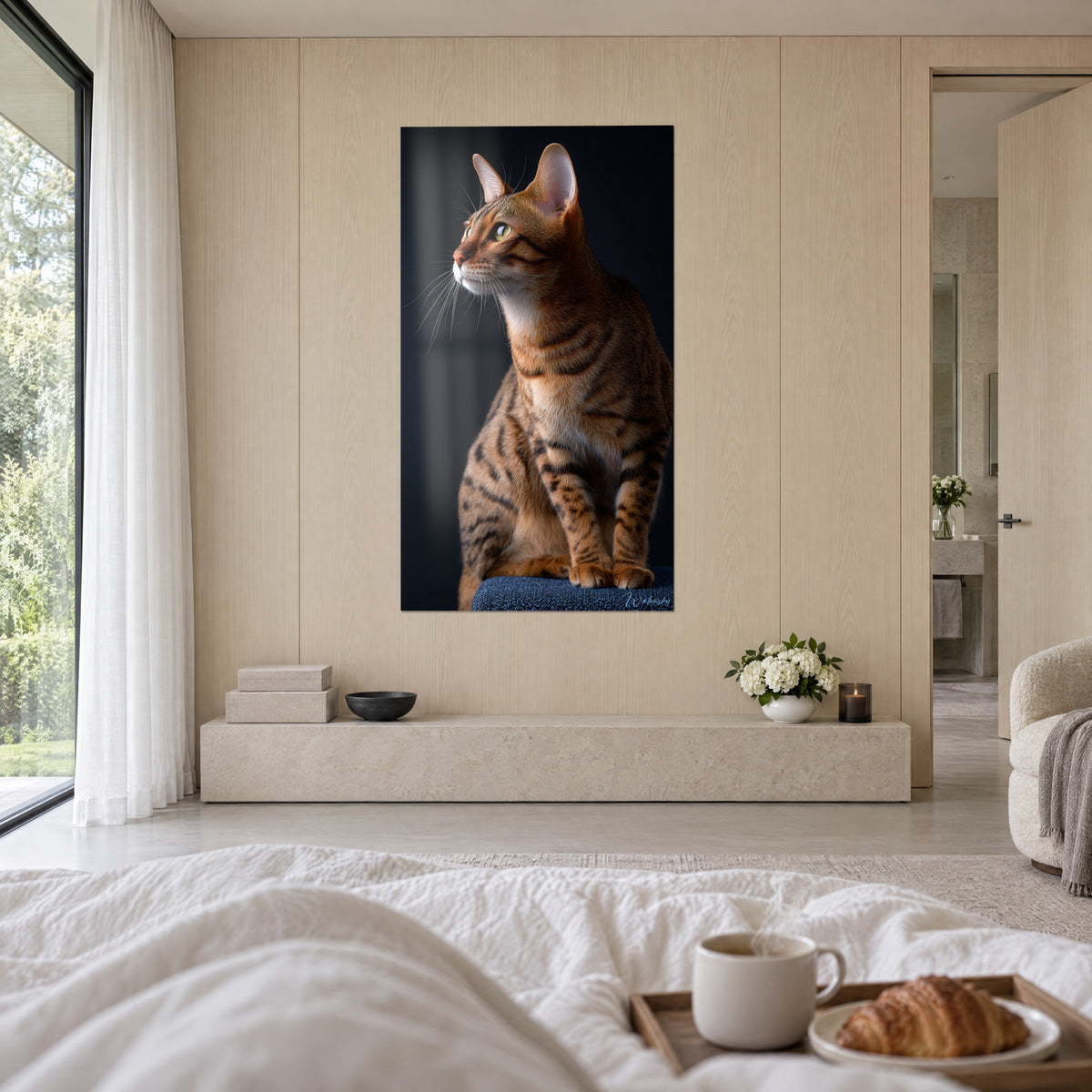 Πίνακας γάτα Toyger πορτοκαλί και κρεμ, με πόδια ριγέ μαύρα πάνω σε μπλε πουφ, μπροστά σε μεγάλο λευκό κρεβάτι σε φωτεινό υπνοδωμάτιο