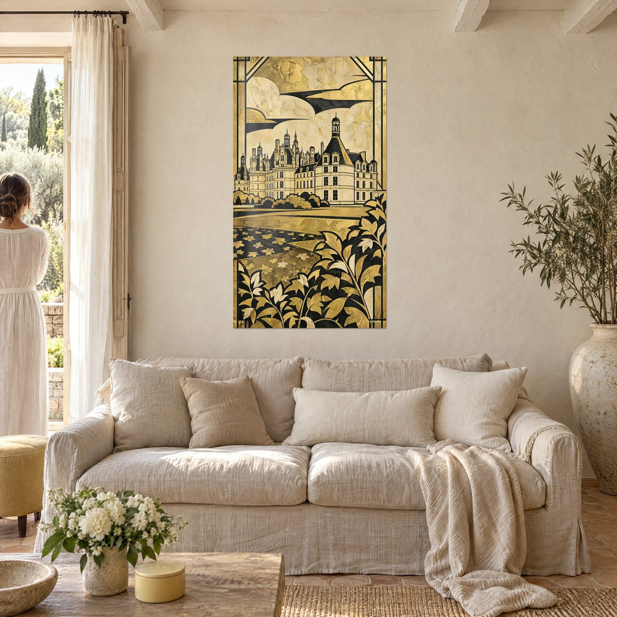Wall art of Chambord castle in gold with black roofs, ivory leaf frieze, two people seen from behind above a sofa in a bright living room